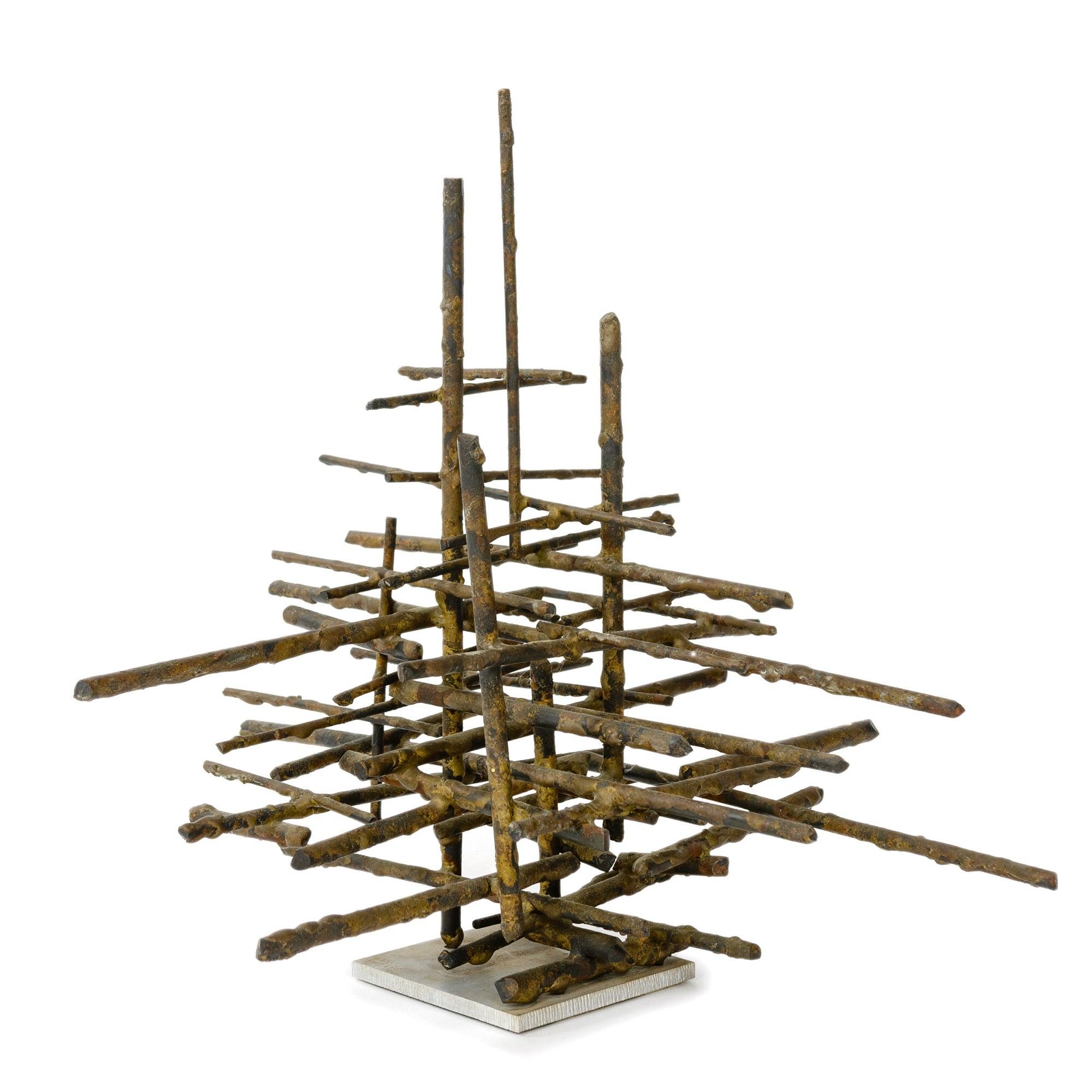 Sculpture de table brutaliste composée d'un assemblage linéaire de tiges de bronze de différentes longueurs empilées sur une base carrée en aluminium. Les lettres 