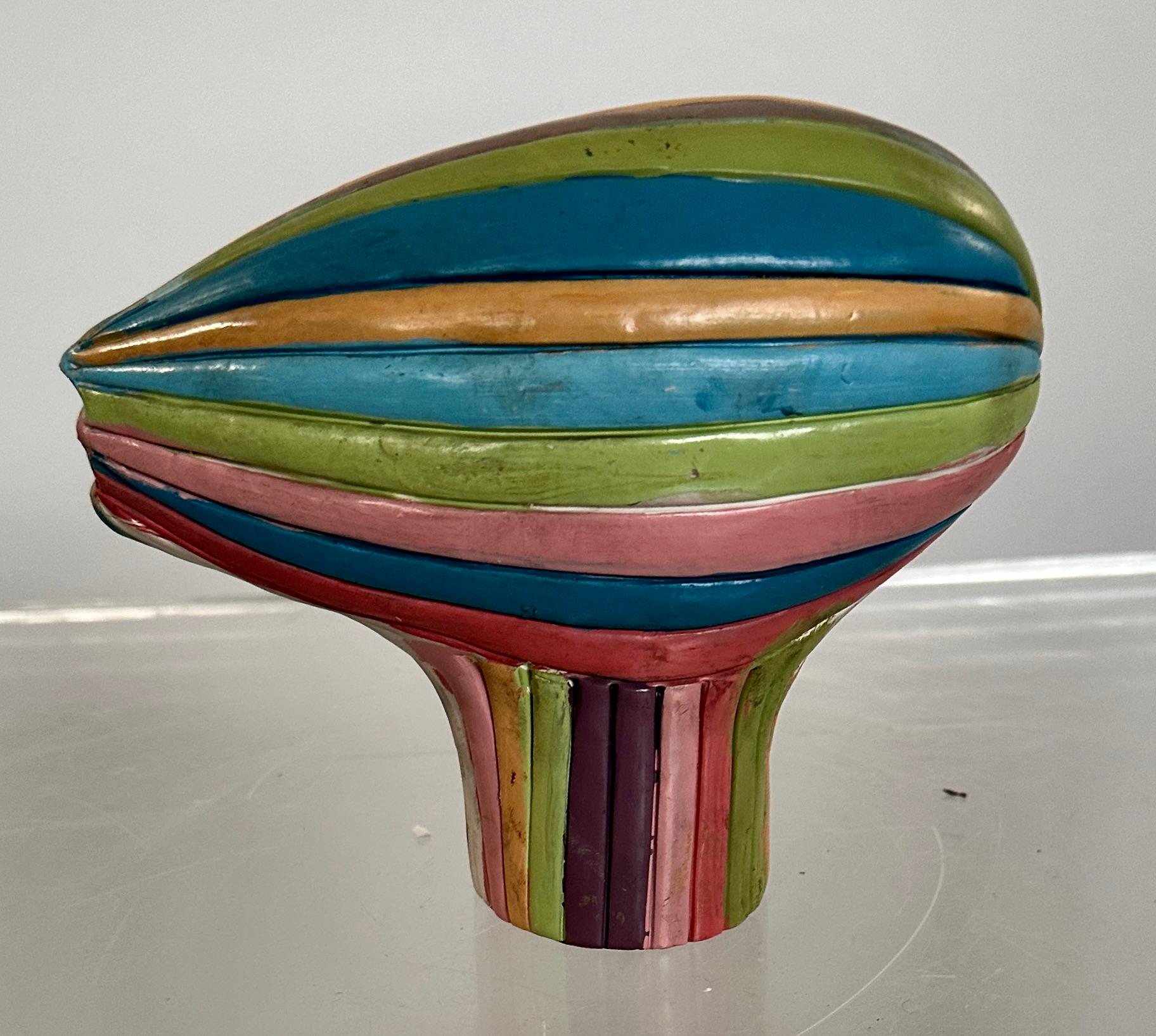 Esta obra del célebre artista Alexander Ney es una de sus formas repetidas, a la que llamamos cabeza de hacha. Éste es de terracota esmaltada en varios colores. 

Nacido en Leningrado en 1939, Alexander Ney pertenece a una generación de artistas