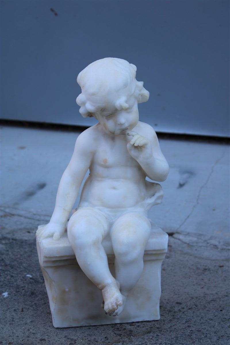 Sculpture in white alabaster 1910 with a child sitting on a wall thinking
