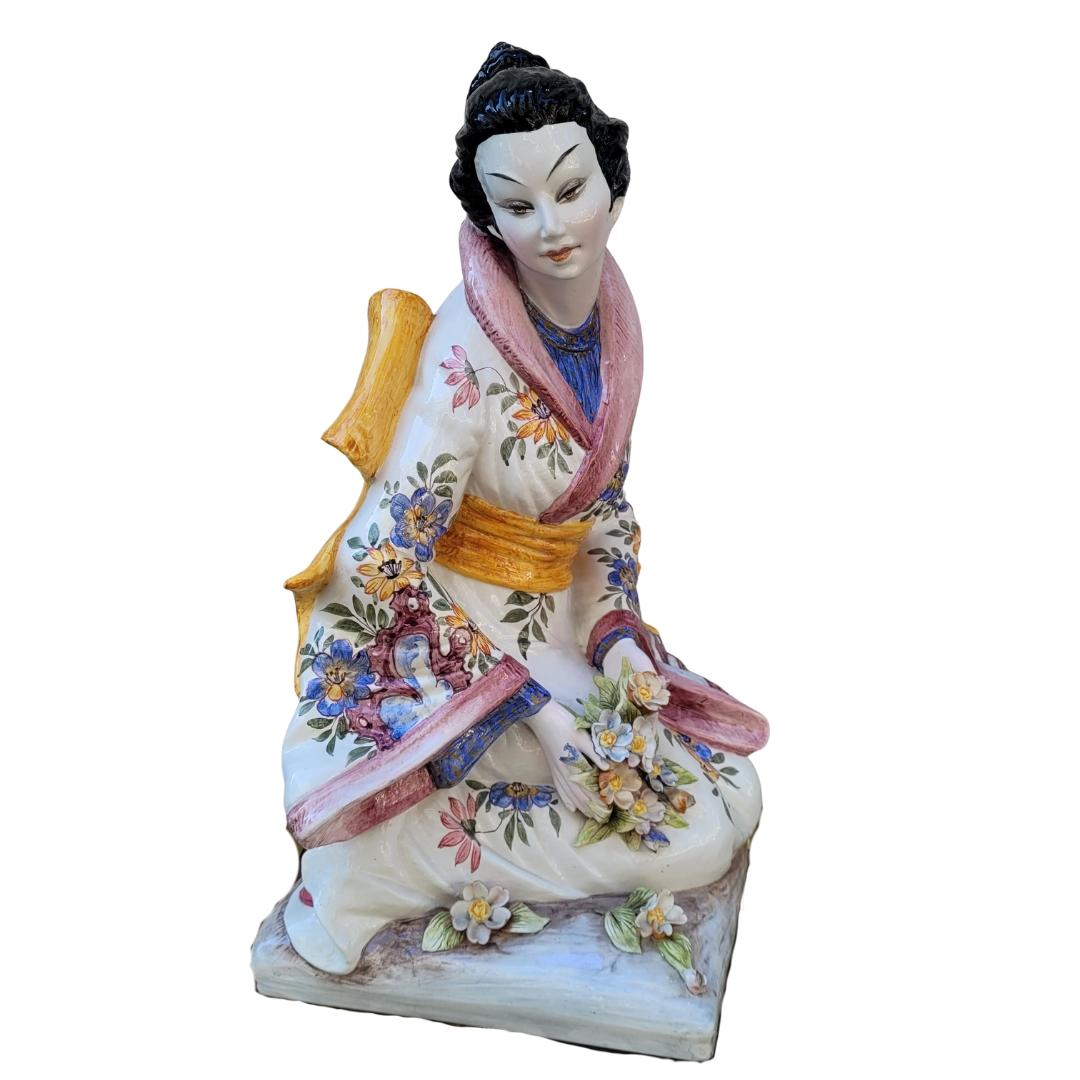 Étonnante sculpture en porcelaine représentant une geisha, réalisée par le céramiste italien Domenico Poloniato dans les années 1960. Les geishas japonaises étaient des femmes qui animaient les banquets et les réunions en jouant de la musique, en