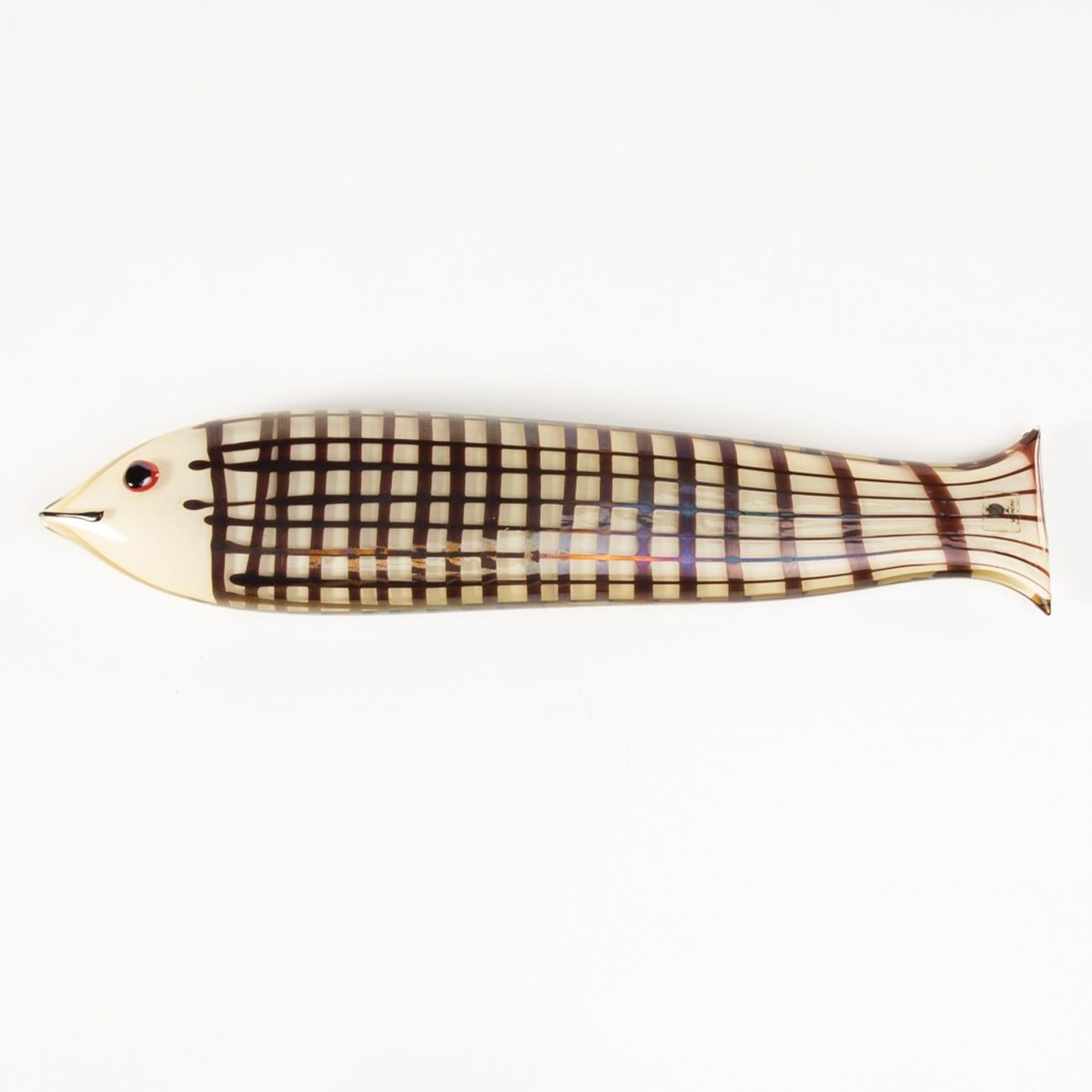 This large fish measures 36 centimeters long in opaque clear amber glass and decorated with a grid of dark amethyst glass. The detail of the black eye on a red background. Ken Scott wanted a slightly iridescent surface for this model.

This