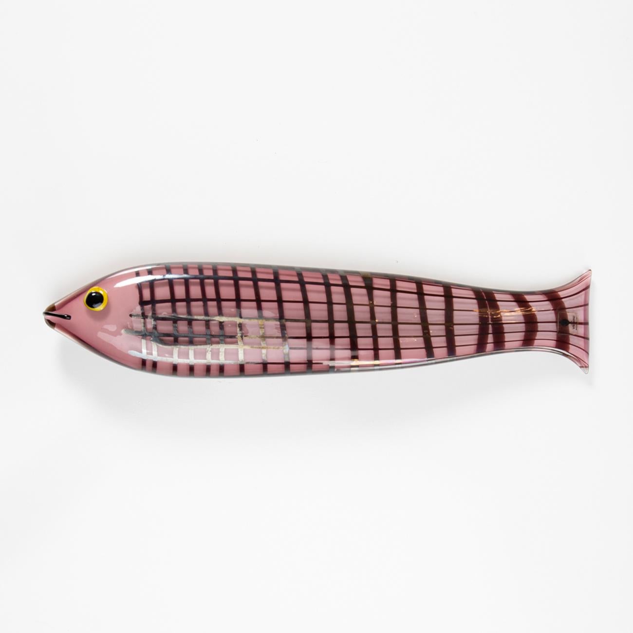This large fish measures 36 centimeters long in opaque amethyst glass and decorated with a grid of dark amethyst glass. The detail of the black eye on a lemon-yellow background. Ken Scott wanted a slightly iridescent surface for this model.

This