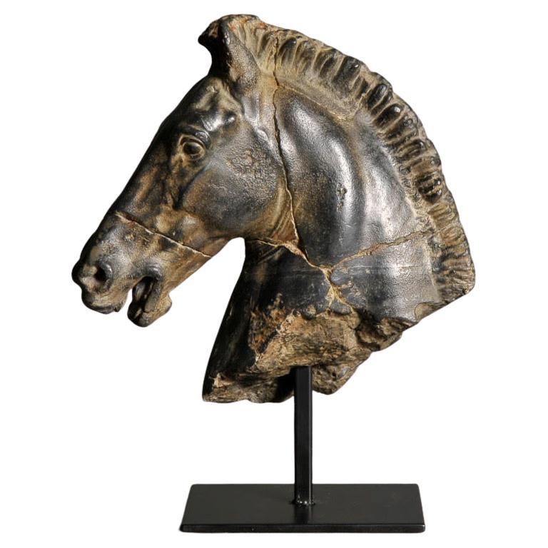 Escultura de la cabeza de un caballo negro.