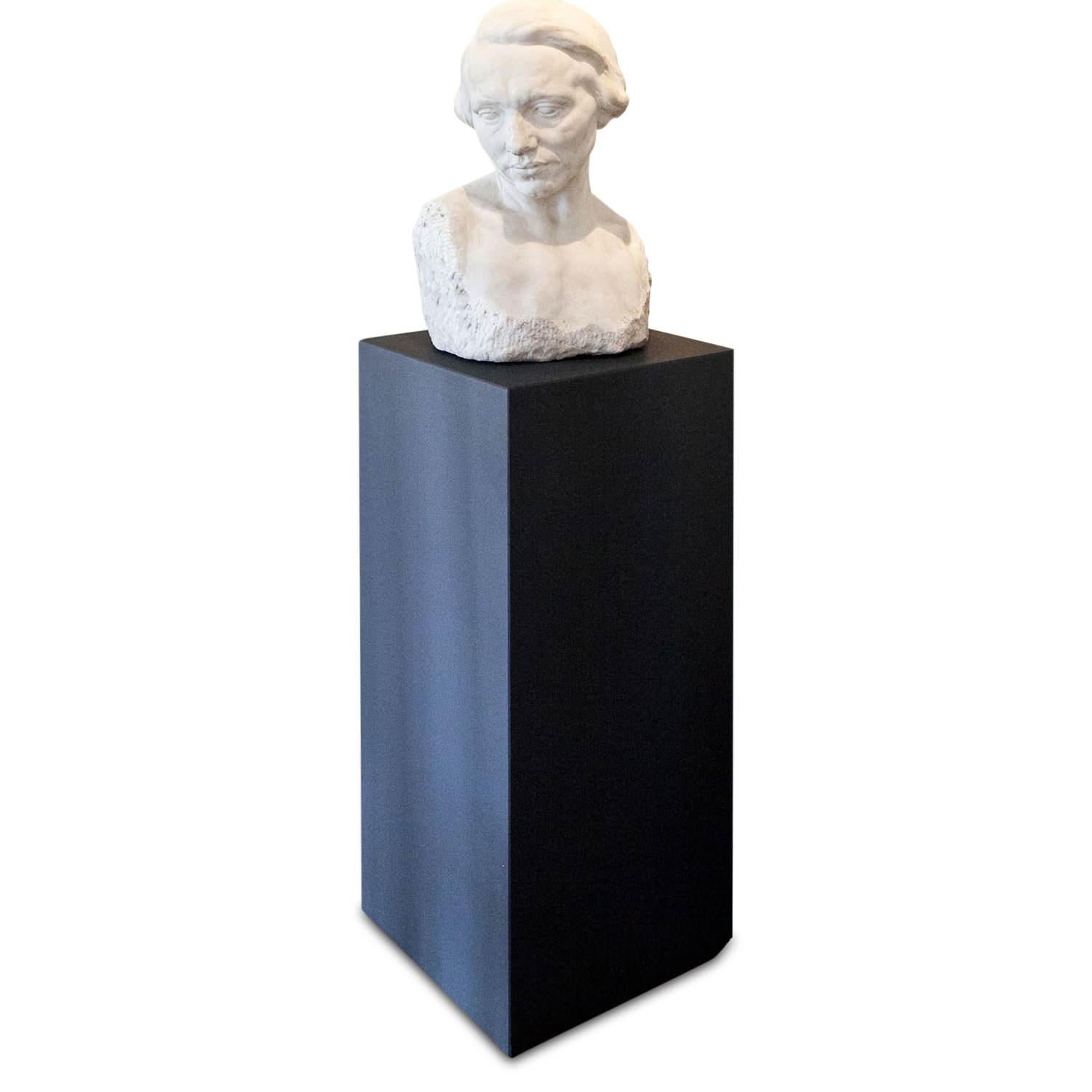 Skulptur aus Marmor von einem unbekannten Bildhauer des frühen 20. Jahrhunderts, die eine Frau mittleren Alters darstellt. Der Oberkörper weist eine teilweise raue Oberfläche auf, der Kopf ist leicht geneigt.