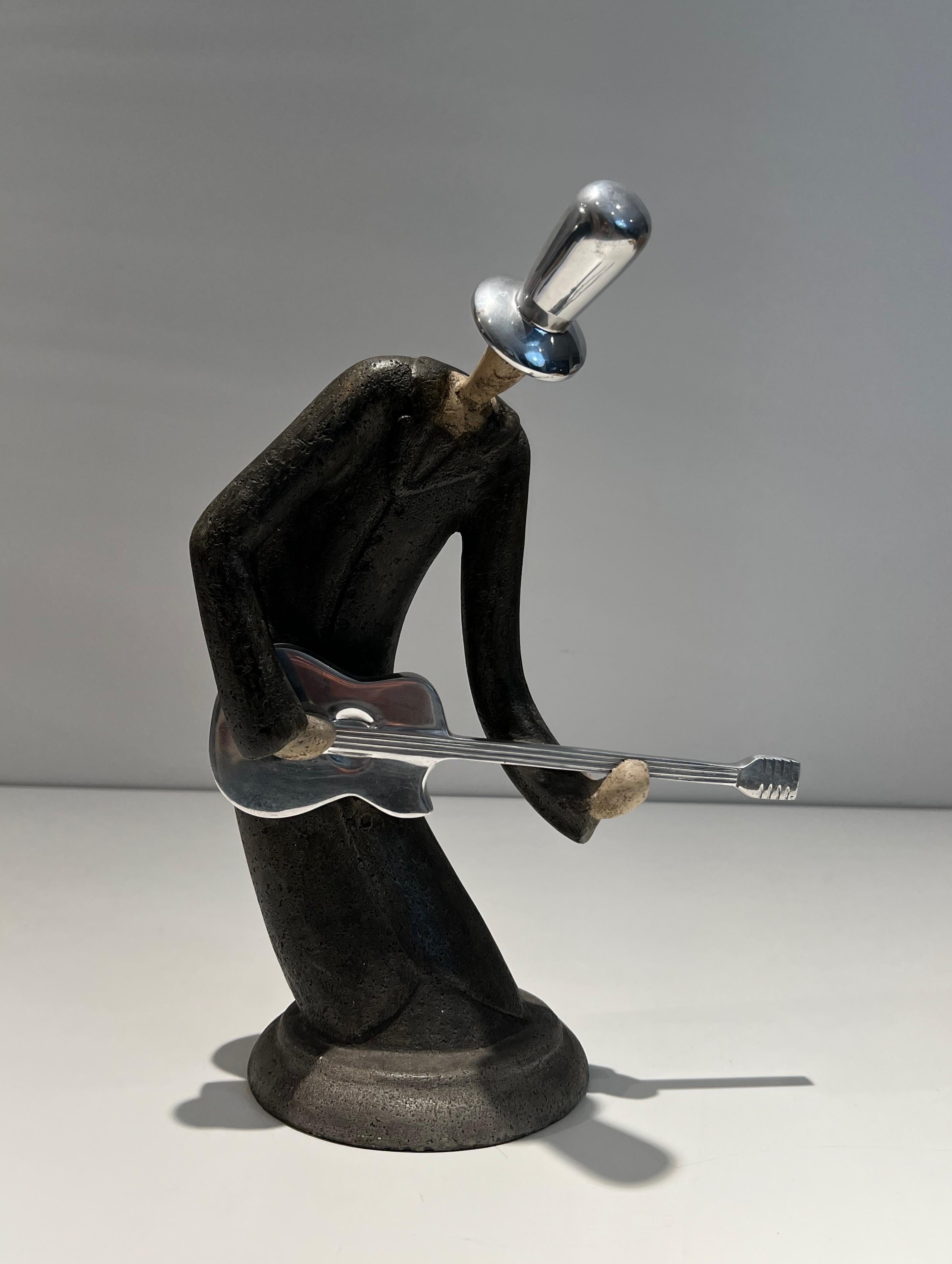Esta bonita y decorativa escultura de un guitarrista está hecha de acero y cromo. Se trata de una obra francesa. Alrededor de 1970