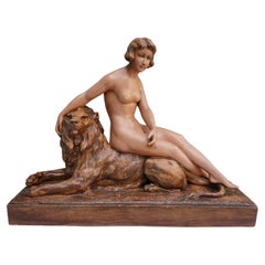Escultura de un desnudo con león. Firmado 'H.Heusers'.