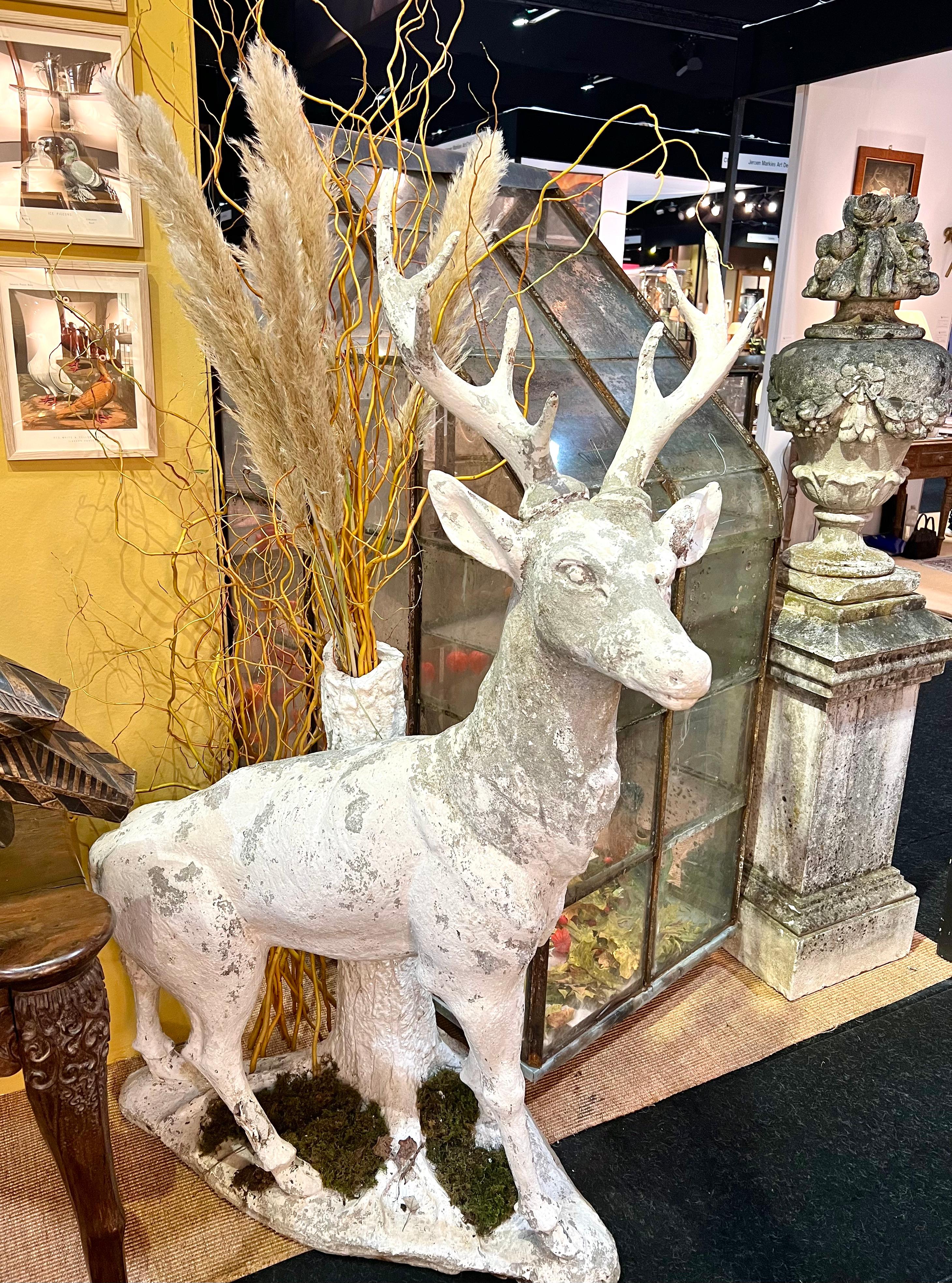 This majestic white cement stag, gracefully poised against a tree trunk, is a stunning example of early 20th-century garden ornamentation. Inspired by the rich tradition of rocaille art, which flourished in the late 19th century, this piece reflects