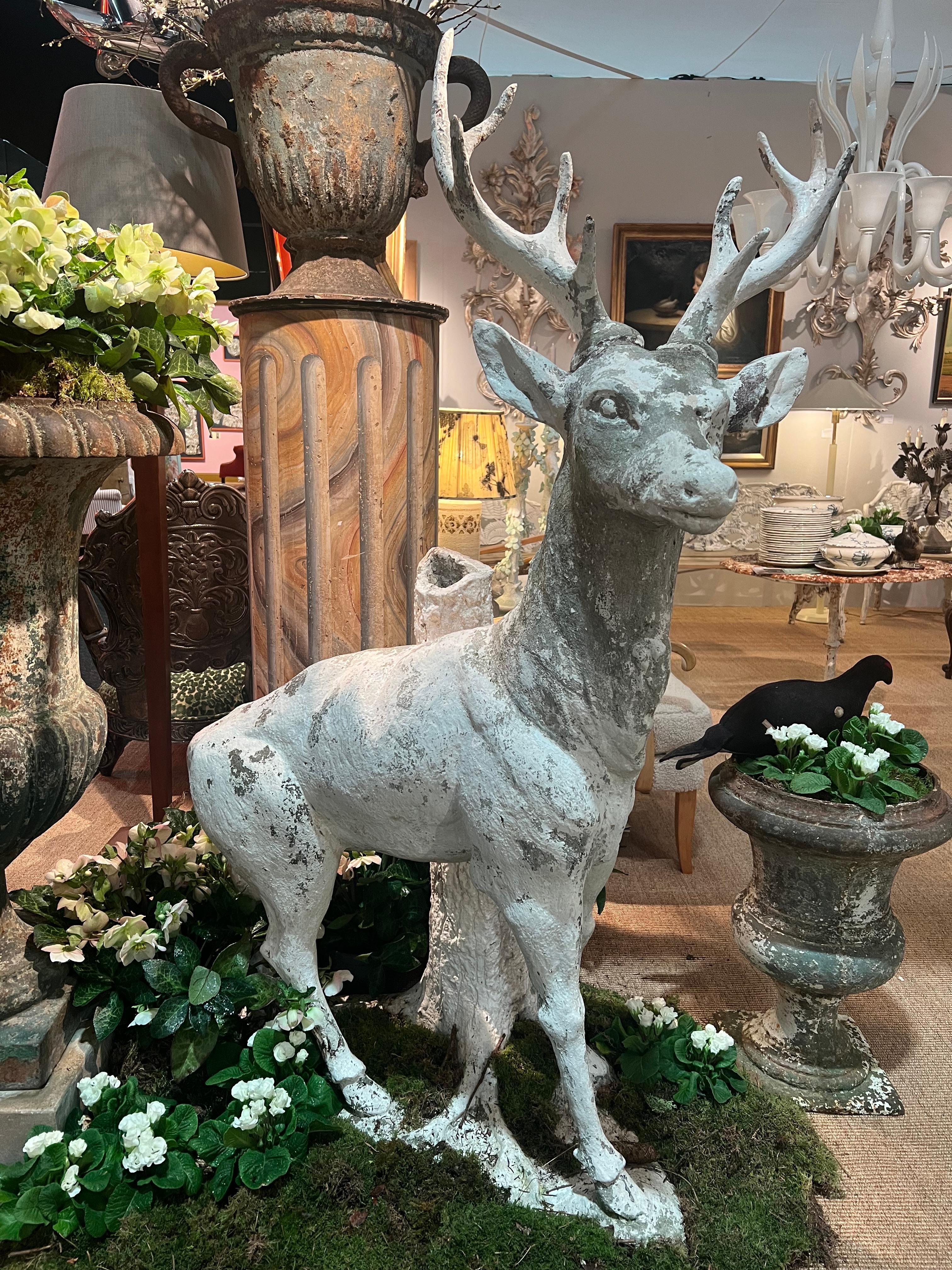 European Sculpture of a stag in white painted cement standing against a tree trunk For Sale
