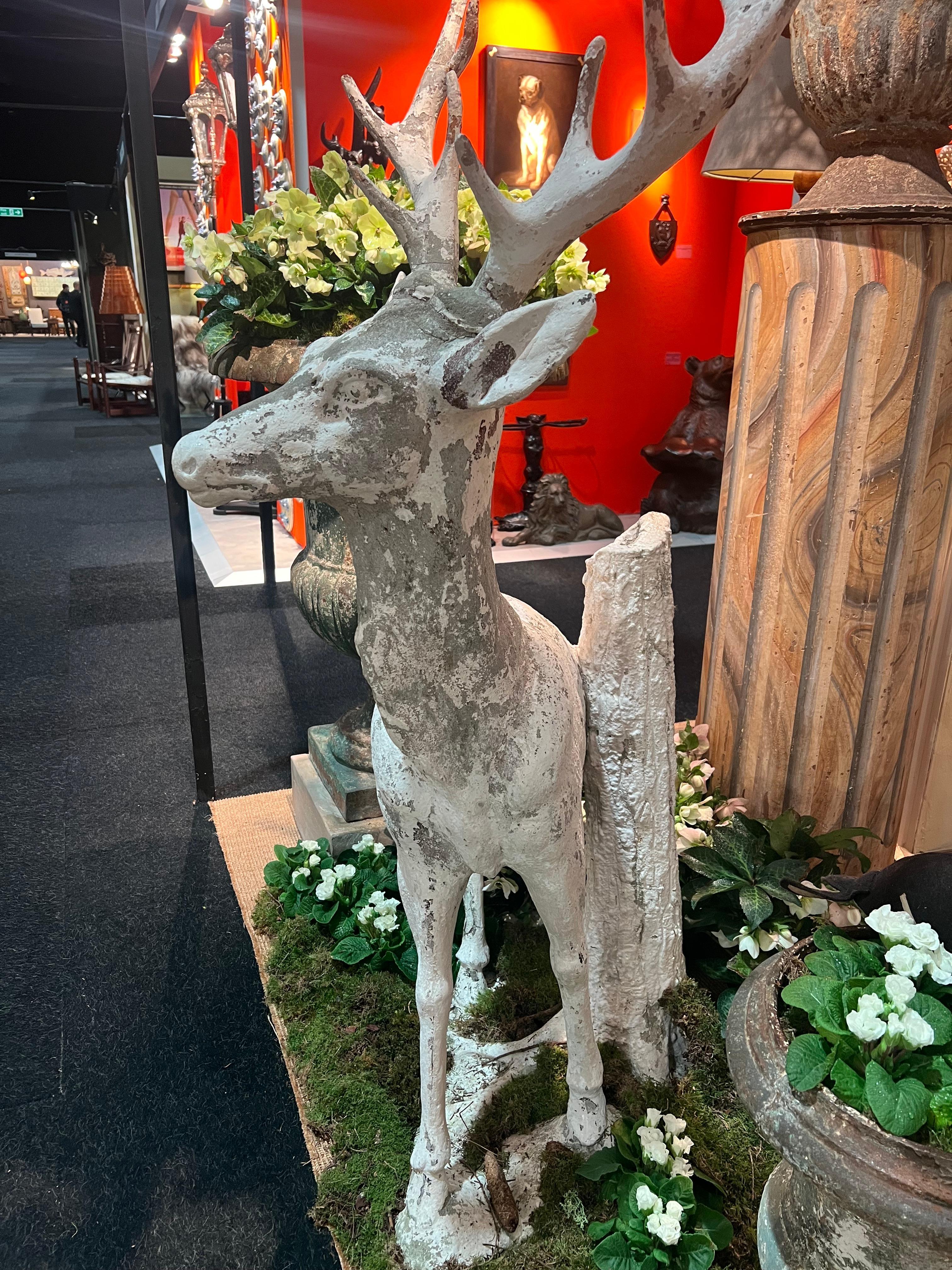 Sculpture of a stag in white painted cement standing against a tree trunk In Good Condition For Sale In PARIS, FR