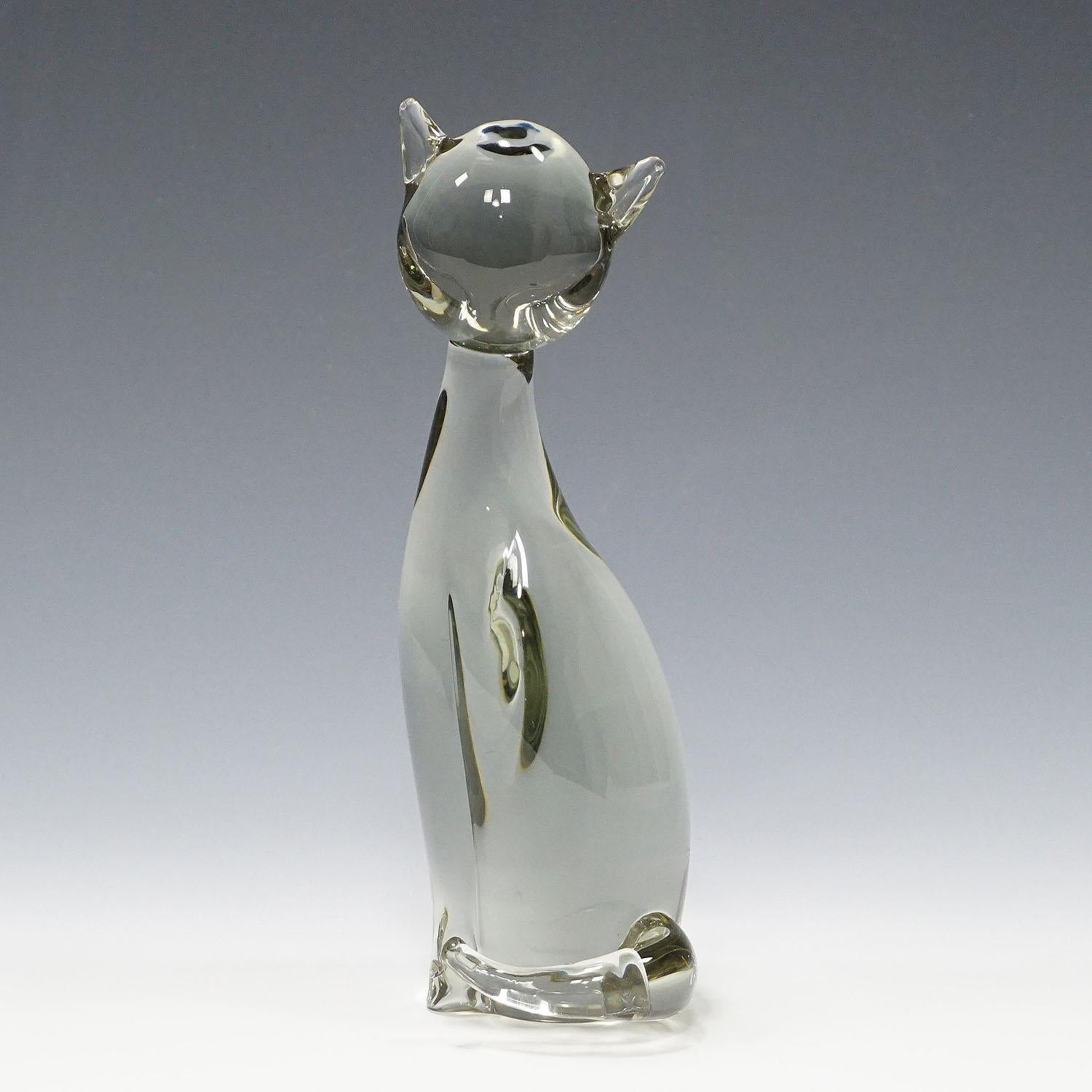 Sculpture of a Stylized Cat Designed by Livio Seguso ca. 1970s

A cute sculpture of a stylized cat in smoke grey glass. Hand made in the Gral glass manufactory, Germany. It was designed by Livio Seguso ca. 1970. With factory lable and incised