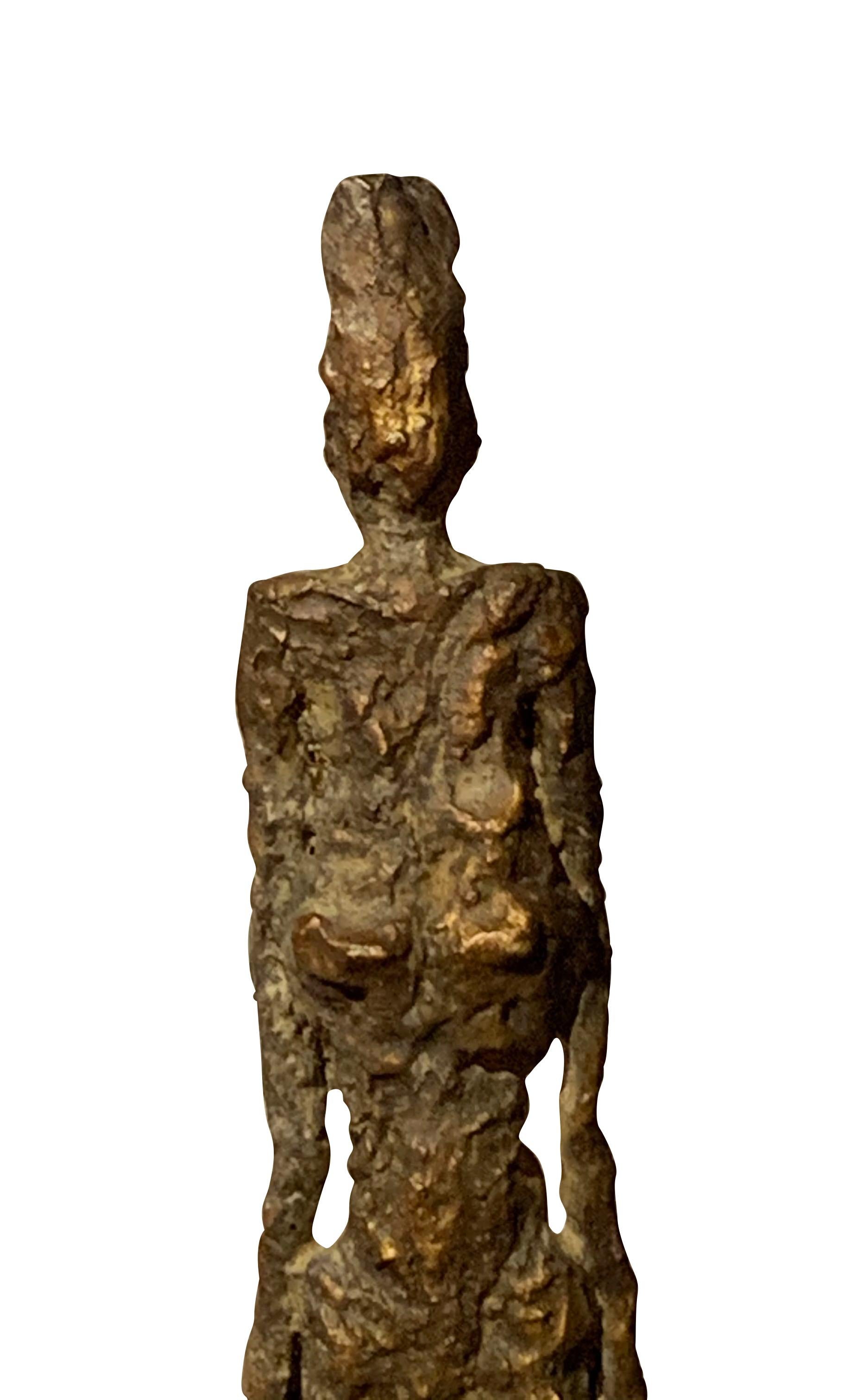 Textured bronze patina sculpture of a standing woman.
She is sculpted in an elongated shape in the style of Giacometti.
The figure stands on a bronze base.
The base measures: 3