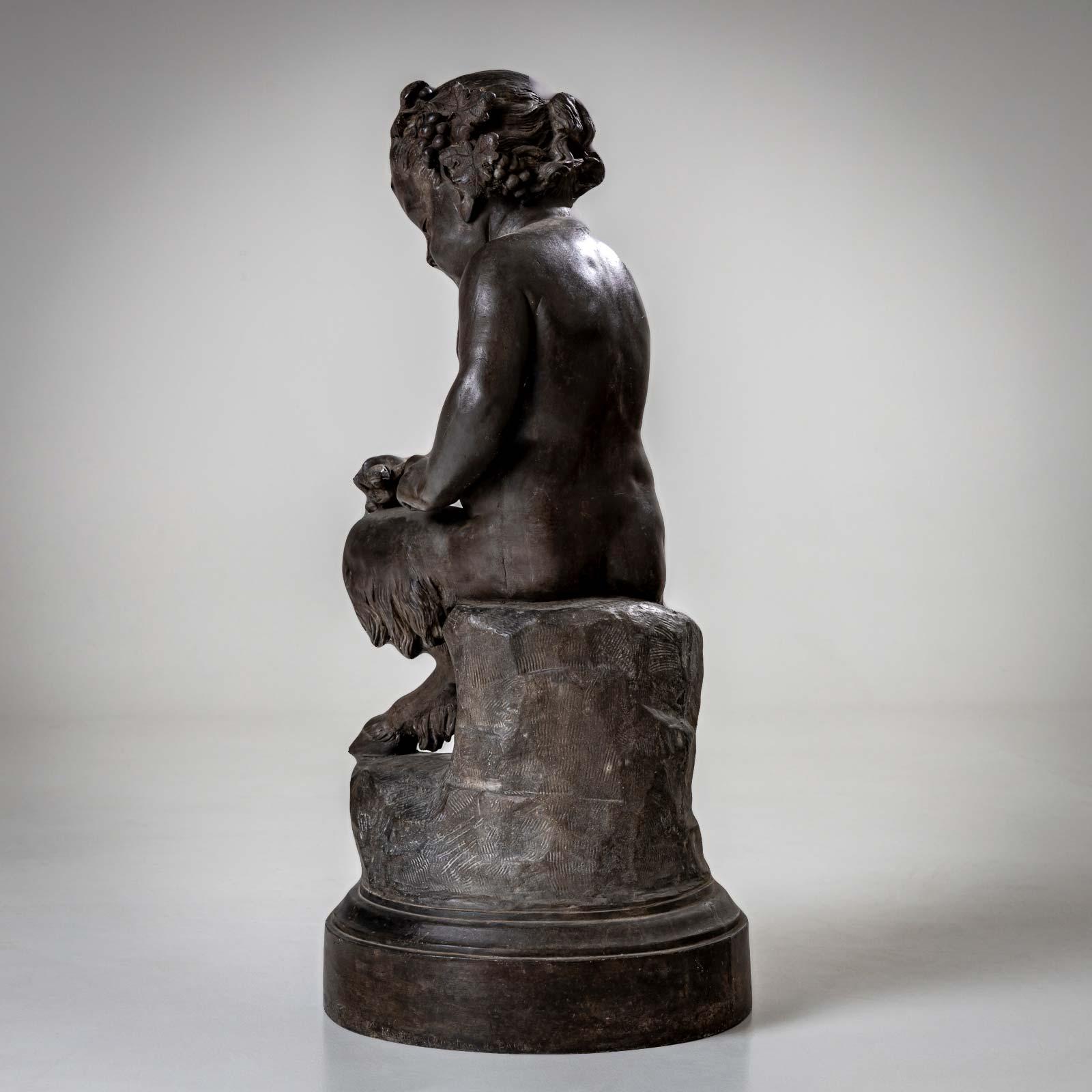 Sculpture noire représentant un jeune satyre sur un piédestal caressant un lézard. Son front est orné de cornes, sa tête d'une couronne de laurier. Diamètre de la base : 36 cm