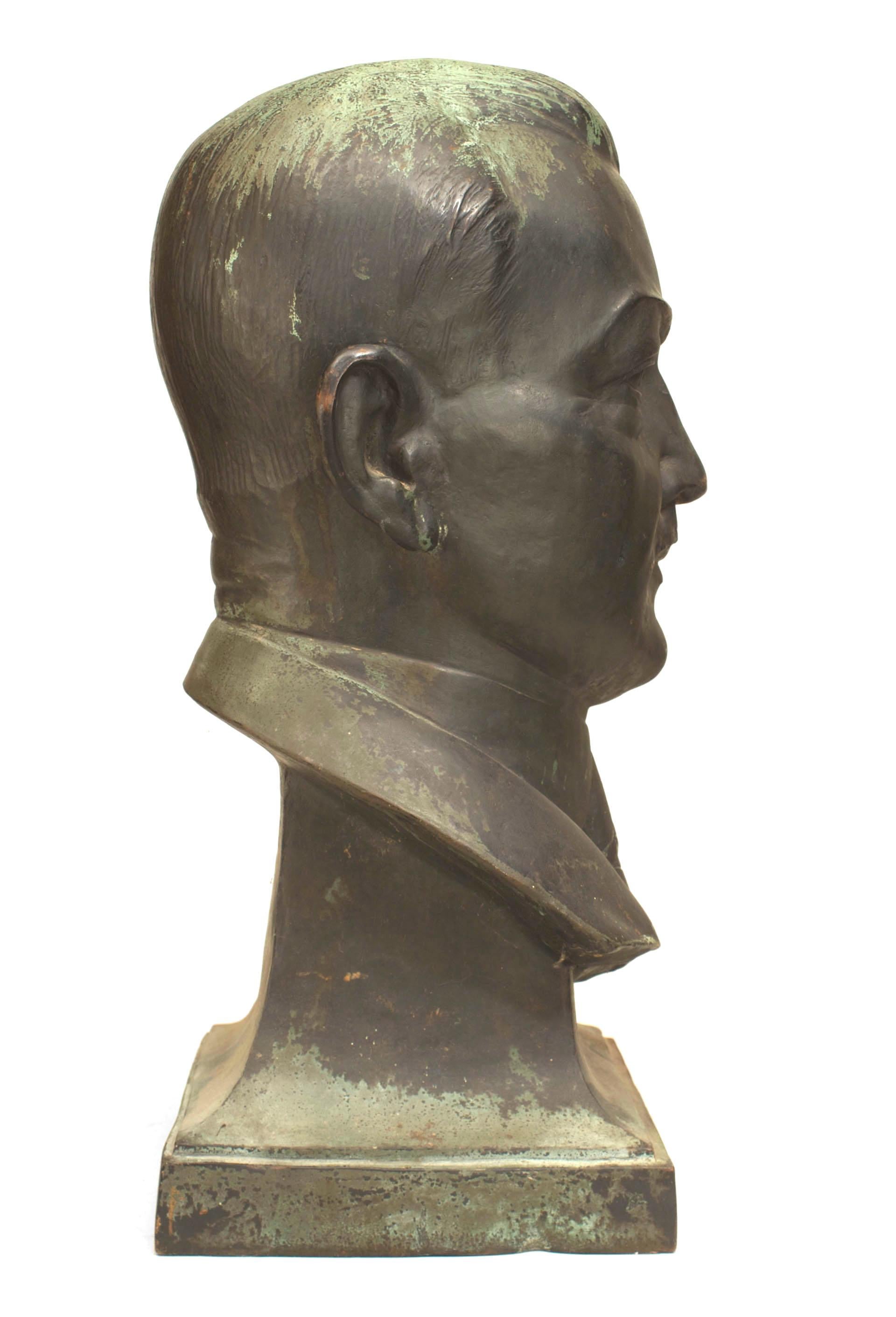 Busto americano del 1940 in bronzo con patina verde di un gentiluomo in giacca e cravatta sollevato su un basamento quadrato
