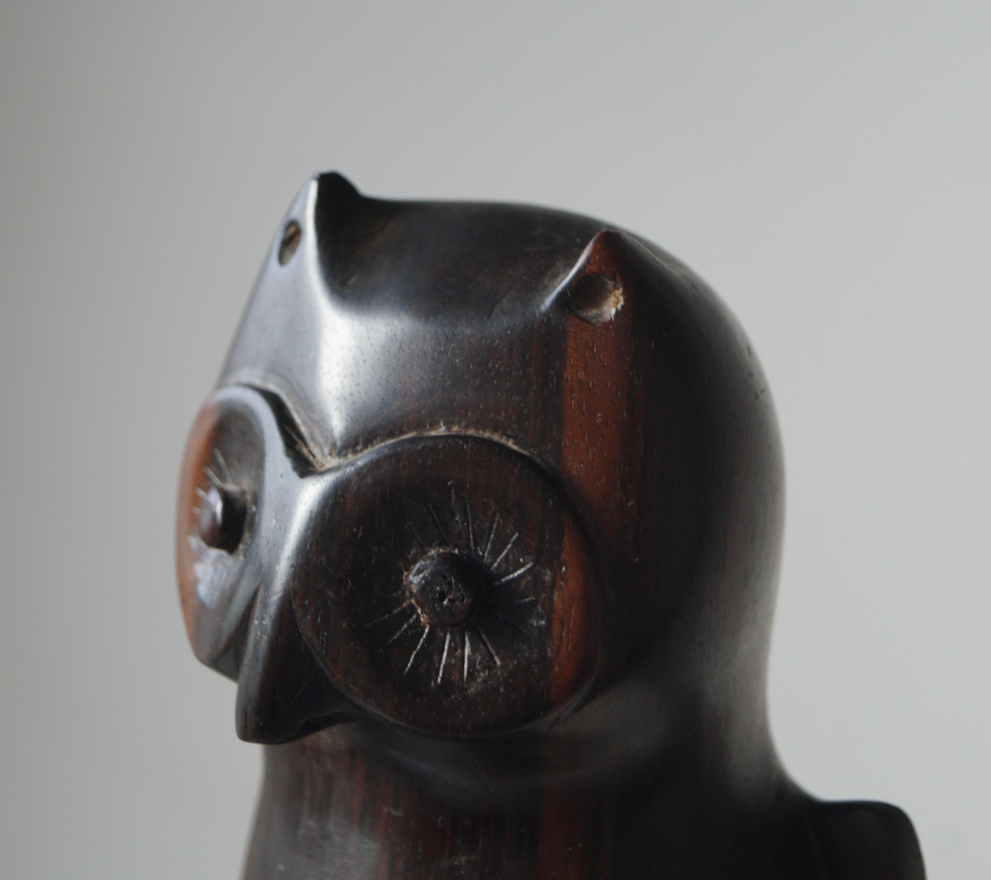 A solid macassar ebony wooden sculpture of an owl. It is clear to see that this owl was made by a skilled artist with an eye for aesthetics, proportions and the ability to bring a sculpture to life. With its slightly tilted, inquisitve and curious