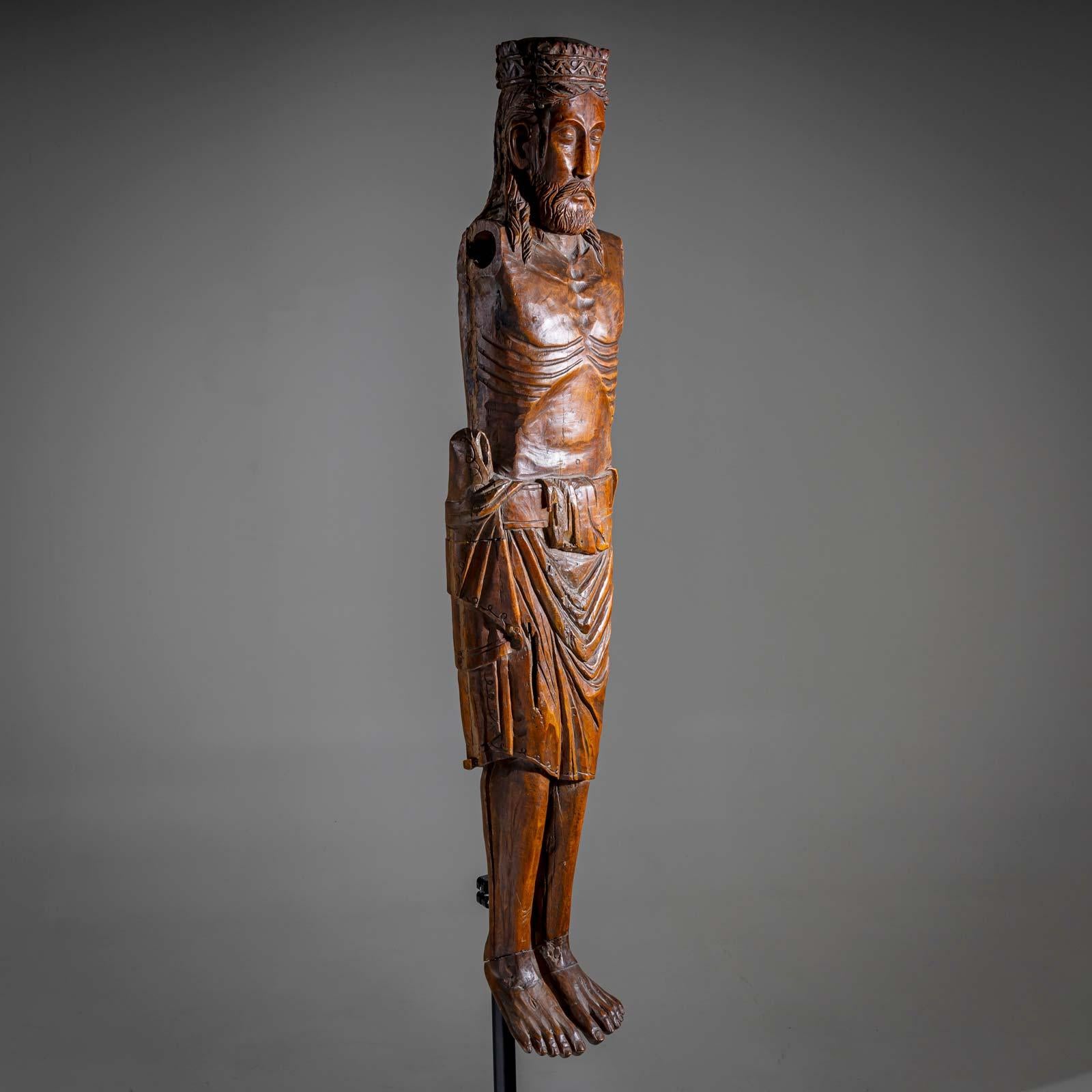 Grande scultura in legno intagliato di Gesù crocifisso con corona e perizoma. Mancano le braccia. Probabilmente è stata progettata come croce trionfale.