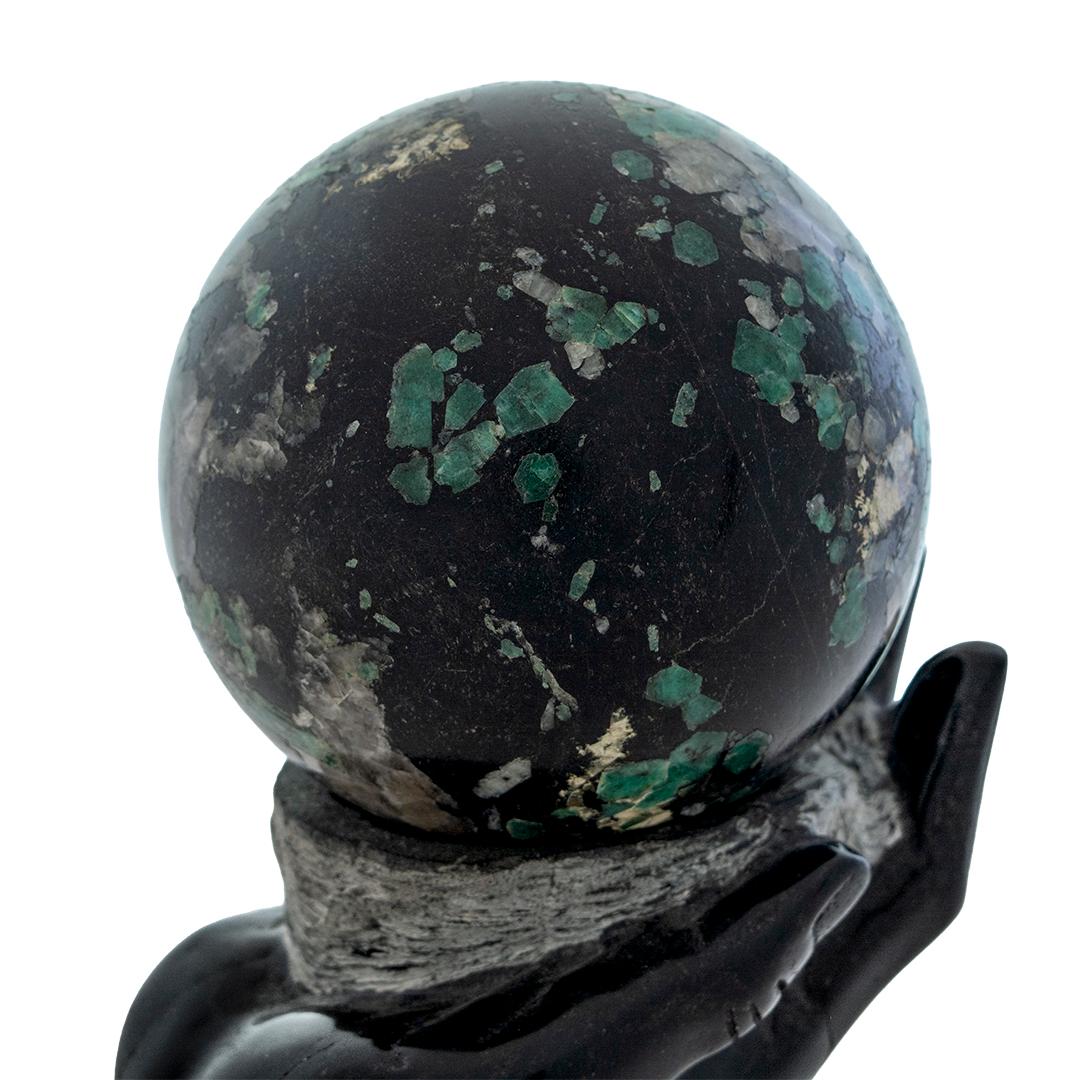 This is an interesting sculpture depicting an extended hand holding a sphere in the palm. The entire sculpture is carved marble.