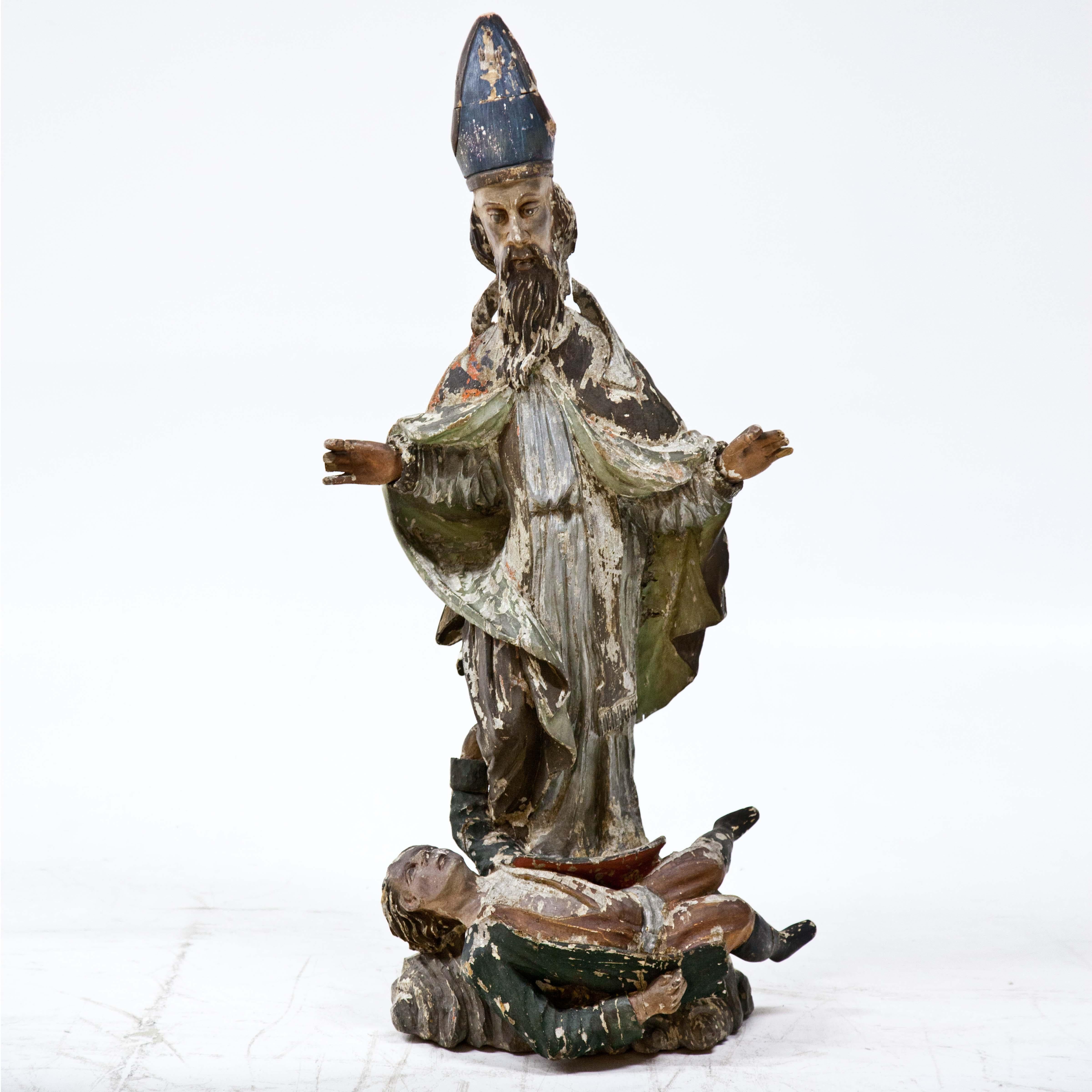 Sculpture of St Valentine carved in polychrome wood with an epileptic at his feet. The setting is heavily worn, fingers partly missing. Back side hollowed. The upper part of the bishop's tiara was old restored.