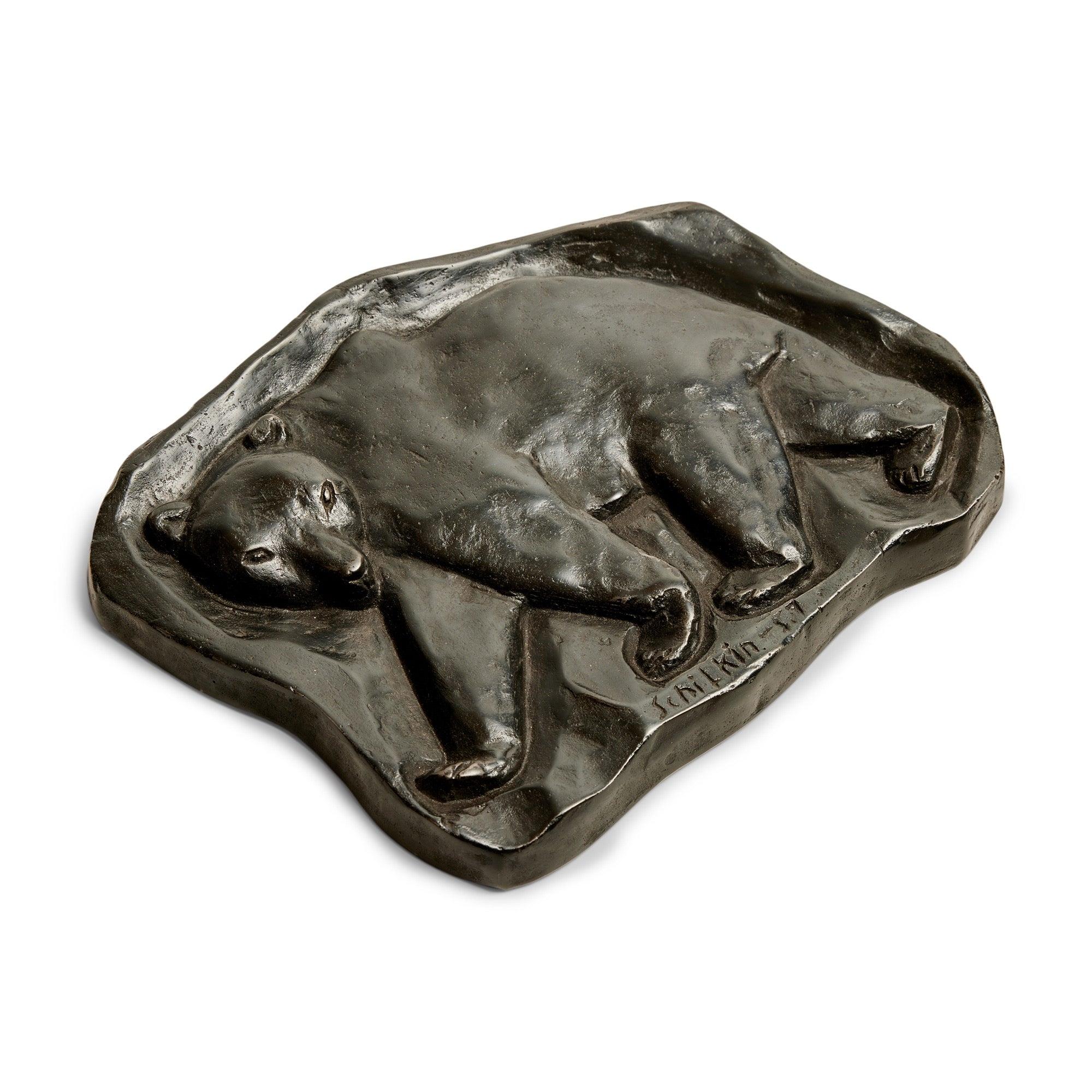 Una targa scultura in ghisa raffigurante un orso polare che cammina, firmata e datata SCHILKIN '57.
