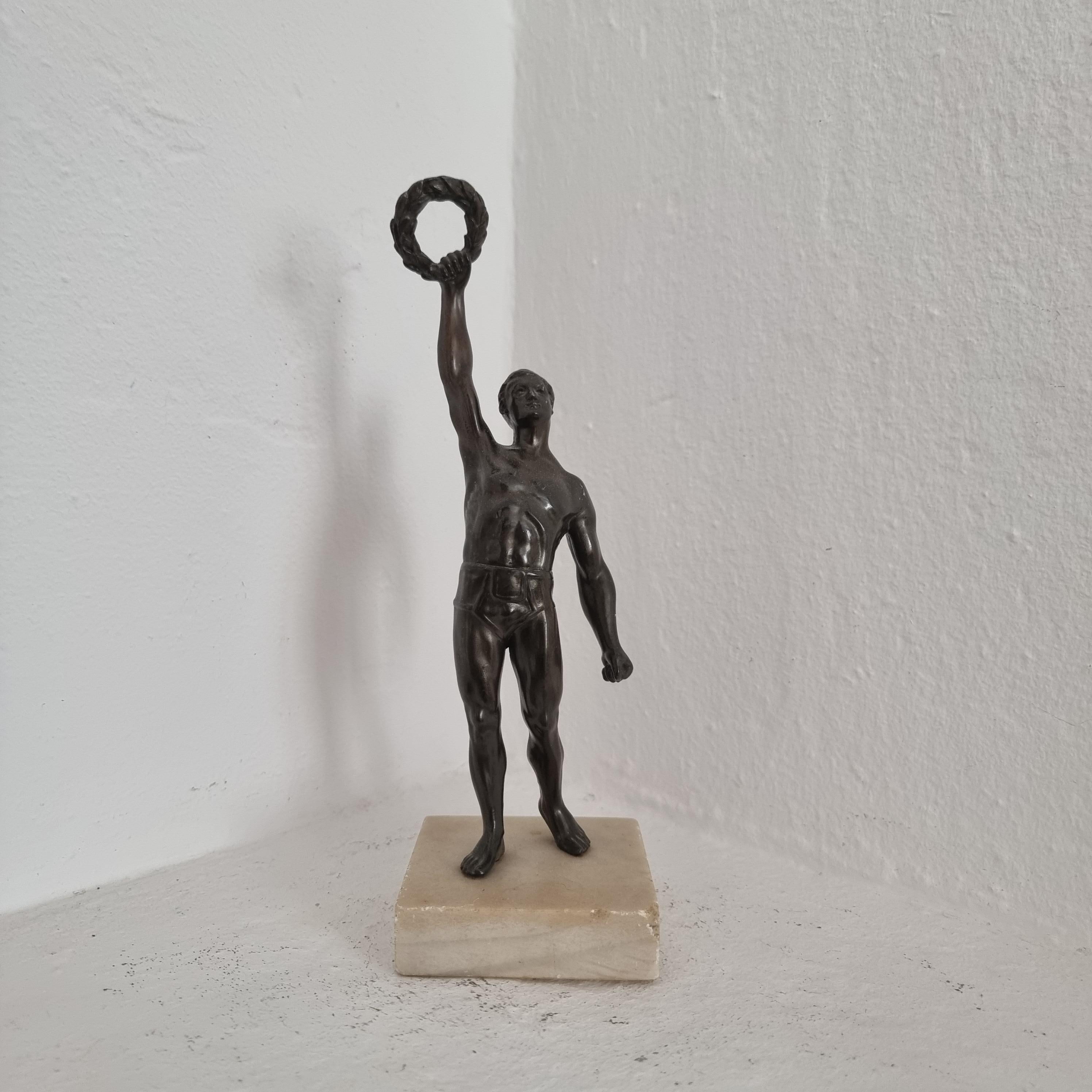 Rare sculpture of athlete with laurel-crown in bronze patinated zinc on marble base. Probably prize for athletes during ca 1930s.

Nice patina, marble with smaller dents and one corner is chipped.