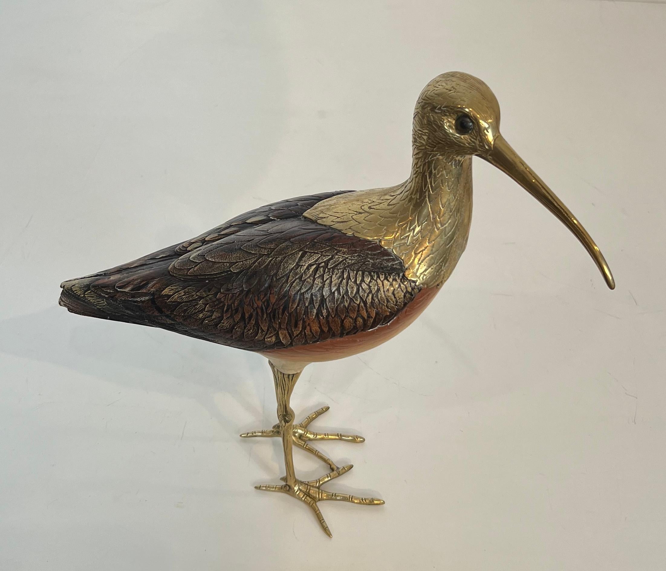 Questa scultura molto bella e raffinata che rappresenta un uccello è realizzata in legno policromo e ottone cesellato. Opera italiana, firmata. Circa 1970