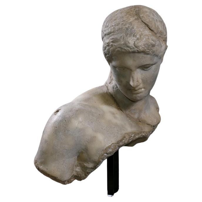 Scultura che rappresenta il busto di un atleta greco del periodo ellenistico, XXI secolo.

Scultura su base di un busto di sportivo greco, in gesso patinato e resina, XXI secolo, modello del Musée du Louvres, Parigi.

H. H. 53 cm, L. 41 cm, P. 22 cm.