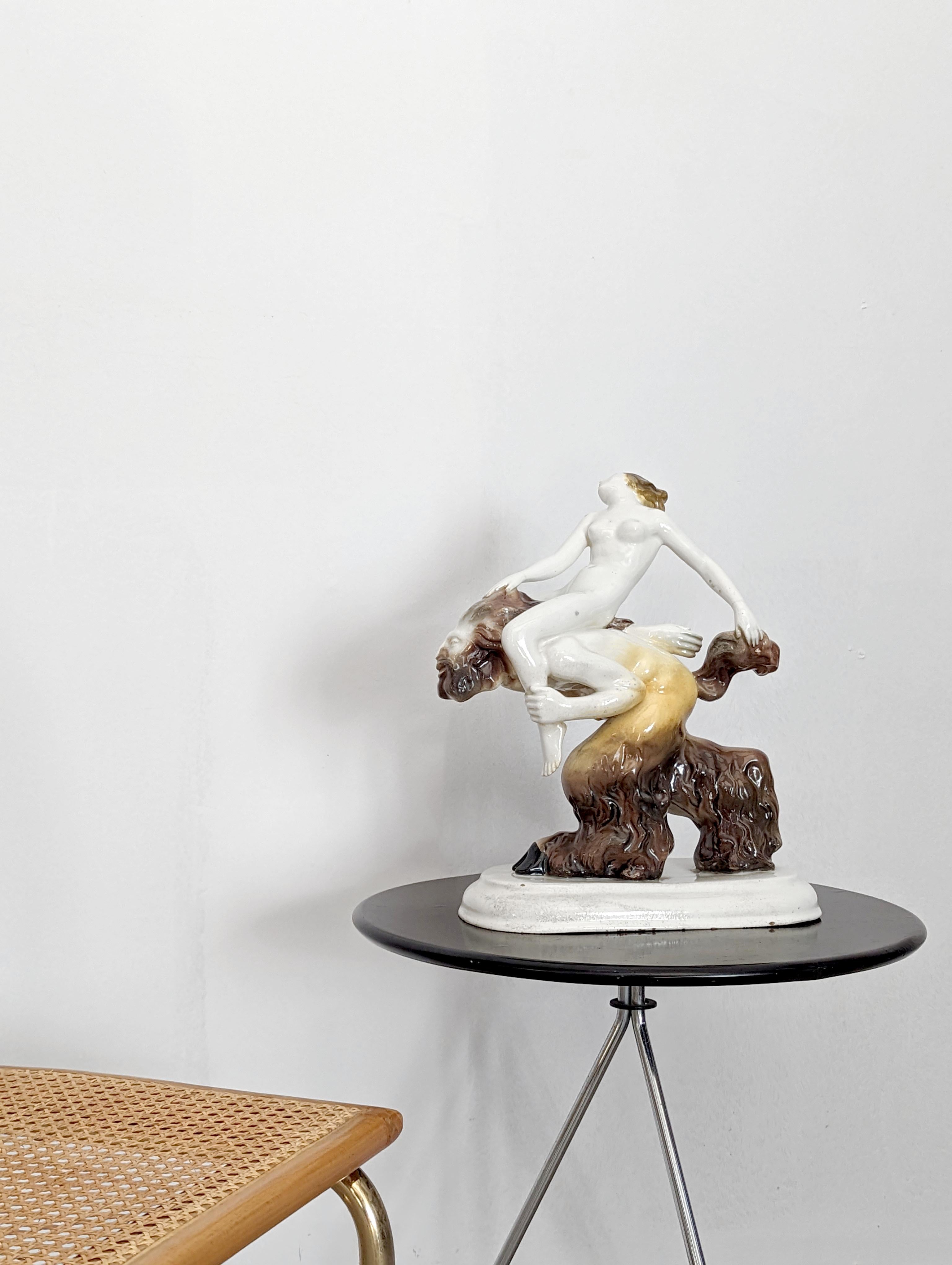 Sculpture en porcelaine précieuse attribuée au concepteur et sculpteur de céramique Friedrich Heuler (1889-1959) représentant le printemps avec une nymphe chevauchant un satyre, auquel elle s'accroche des mains aux cheveux et à la queue. Une