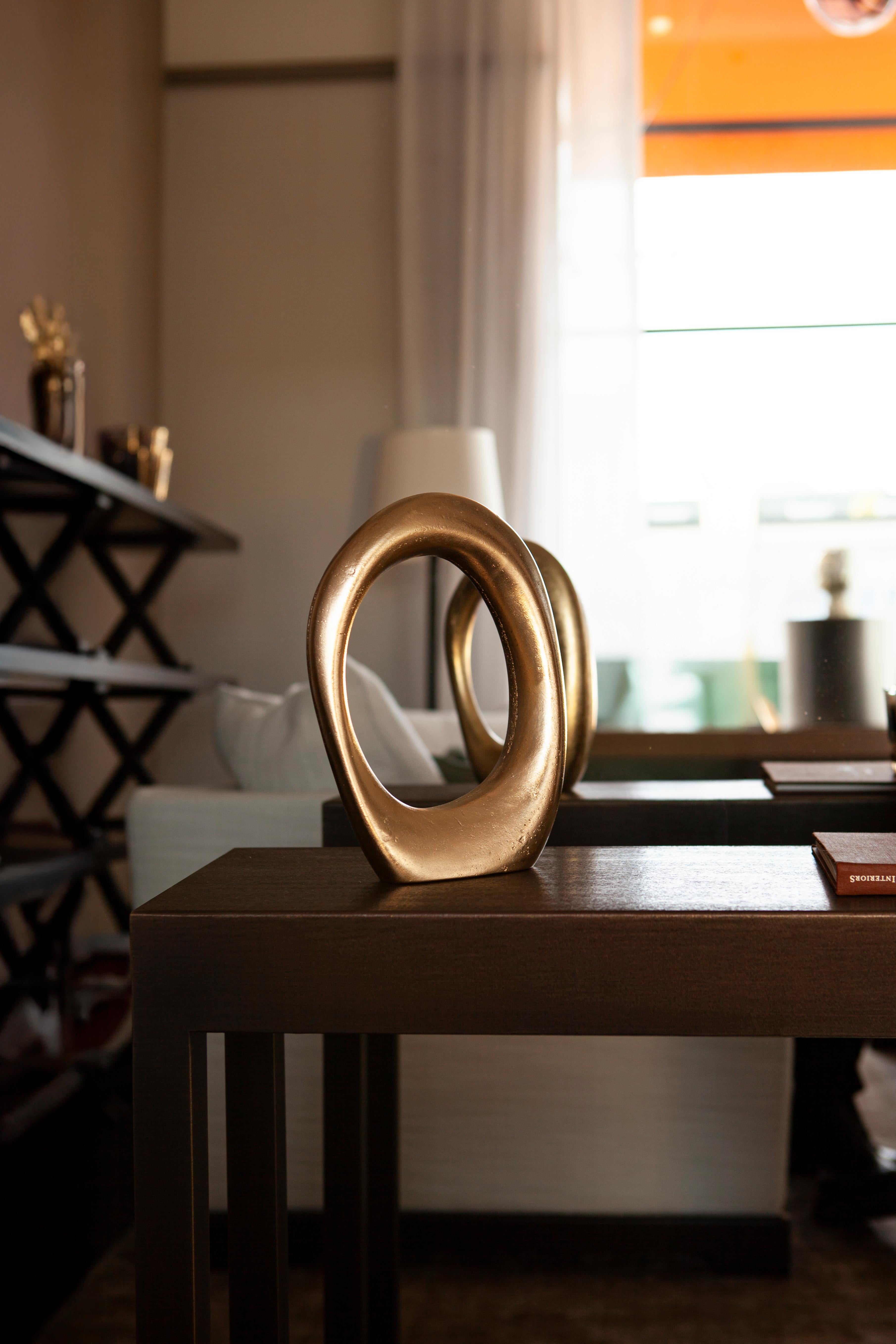 The Fluid Series Sculpture, crafted using the sand-casting technique, features a looped silhouette that captures the gentle flow of liquidity frozen in time. Its continuous, circular form, devoid of a beginning or end, invites quiet contemplation