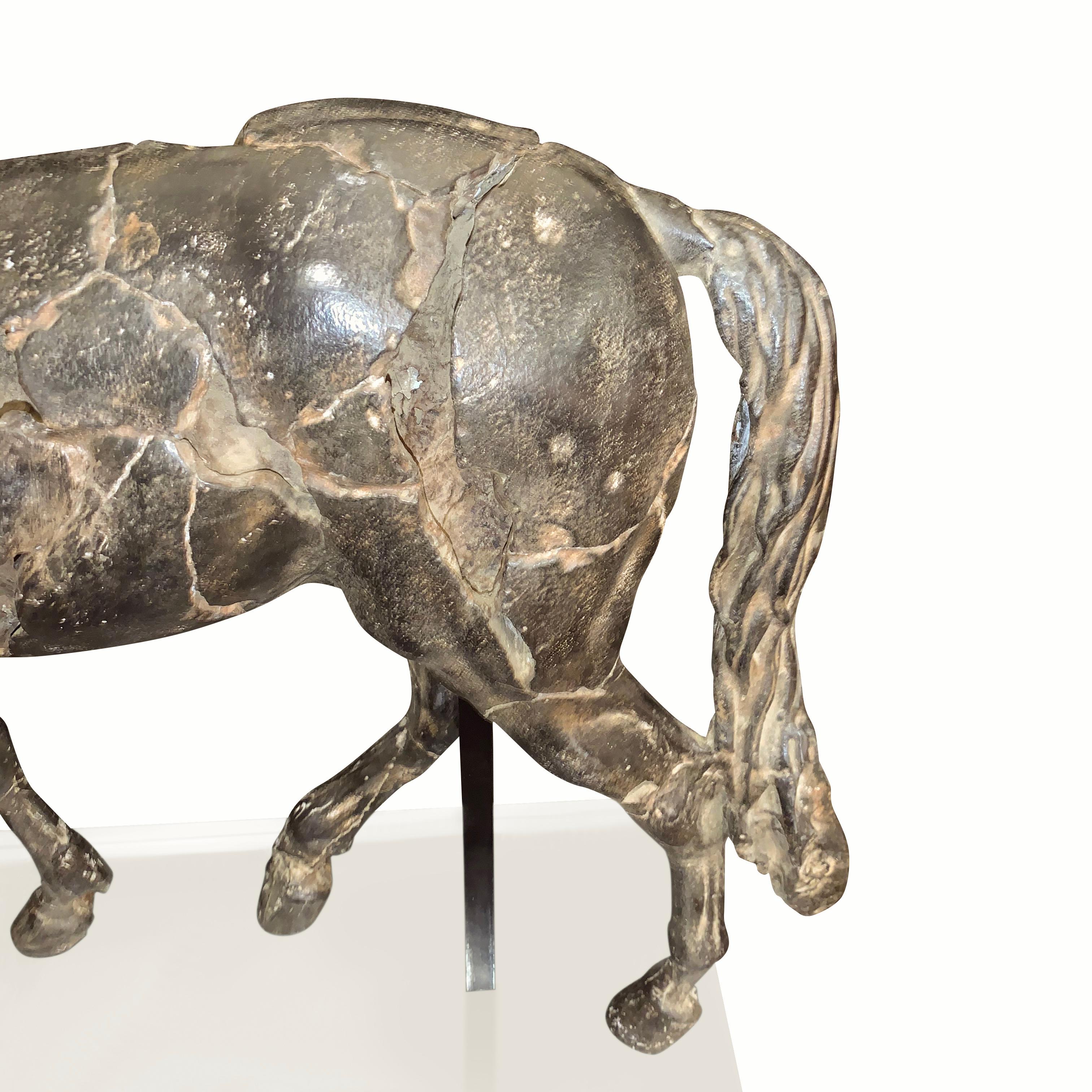 This classic Greek horse sculpture is very realistic in detailing. 
It is sculptured in ground chips of marble creating the appearance of an aged patina.
Lucite base is 16