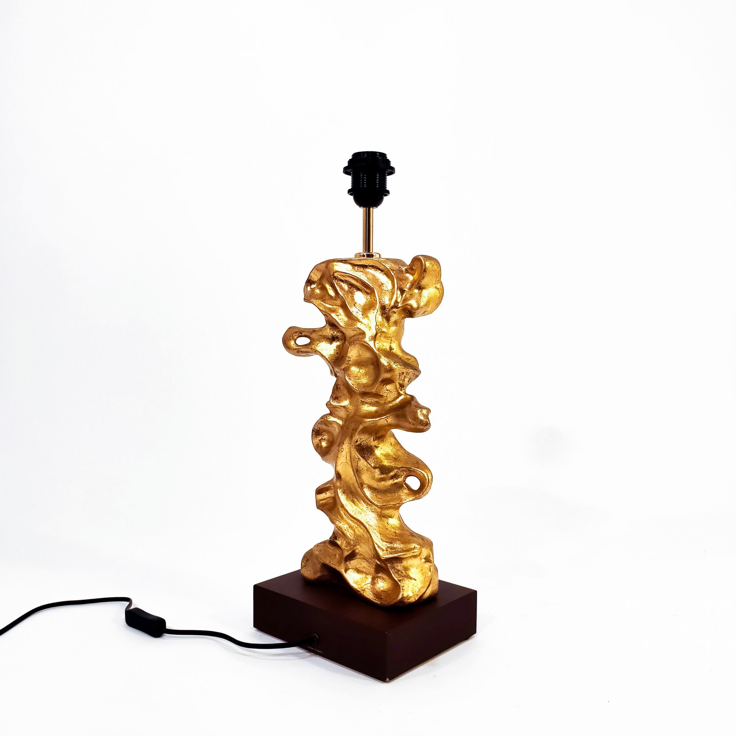 Stunning gilded table lamp by the well-known Valencian ceramicist brand Bondia. Designed and manufactured in the 90s, this sculptural piece is made of plaster and finished in gold leaf on a wooden base. Modern style with a brutalist air, so