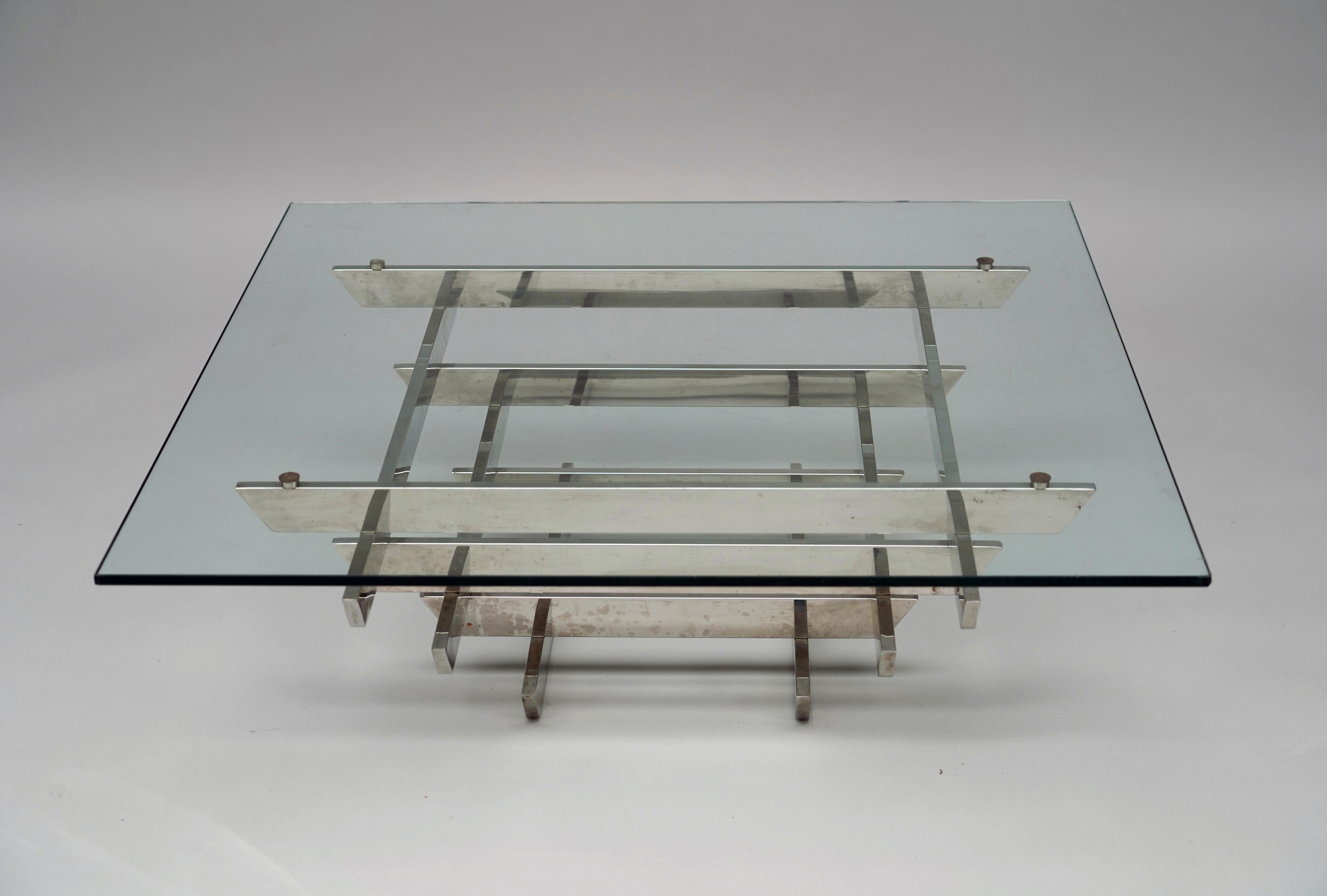 Table basse de forme carrée avec plateau en verre transparent, reposant sur une base pyramidale avec six rangées de barres en acier chromé.

Biographie :
David Nightingale Hicks (1929-1998) a commencé sa carrière de décorateur en 1954 après la