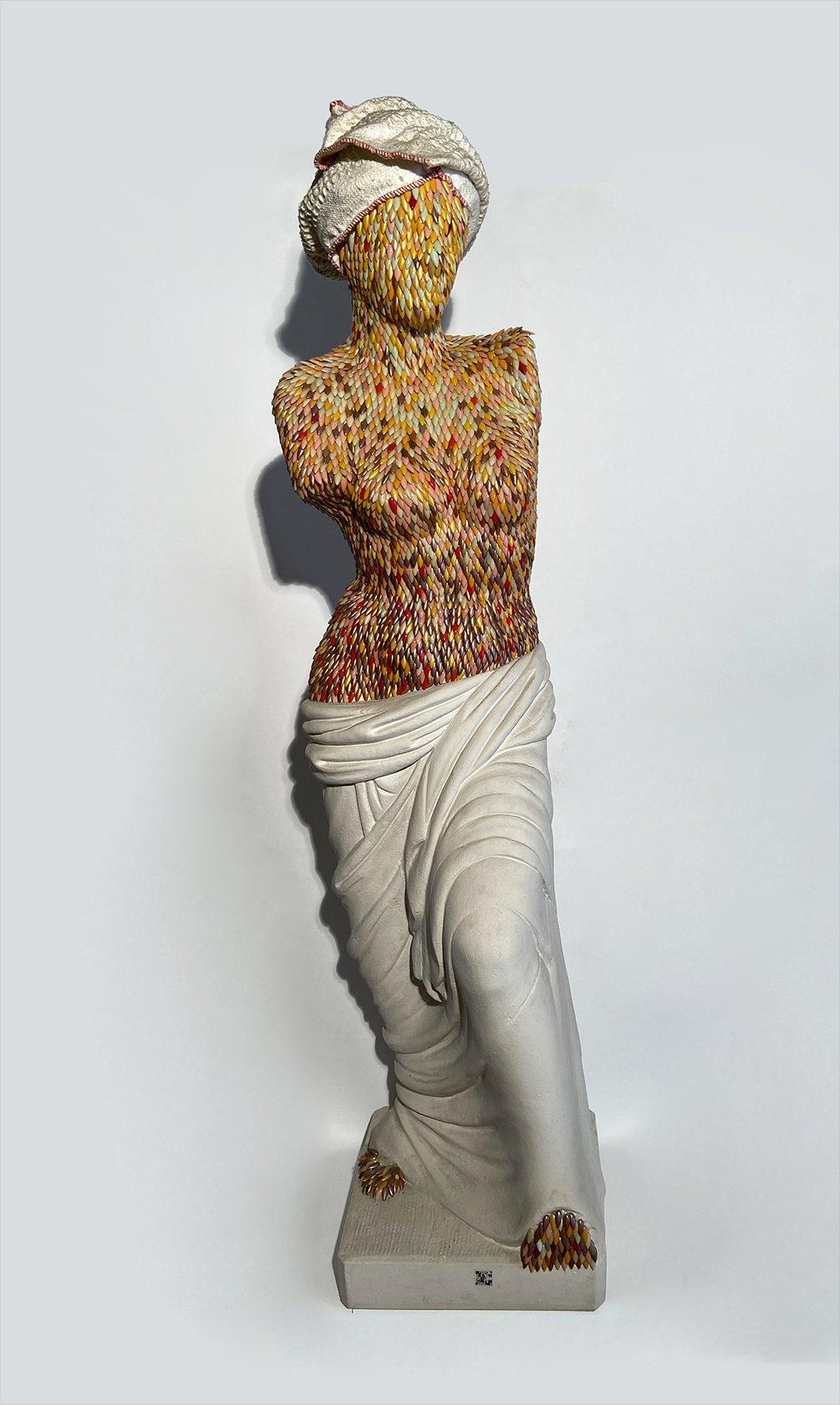 Scultura di donna disegnata e prodotta da Enrica Borghi nel 1999, Italia. La scultura ritrae una figura femminile ed è realizzata con una struttura in materiale plastico, rivestita esternamente da unghie finte colorate che vanno a delineare i tratti