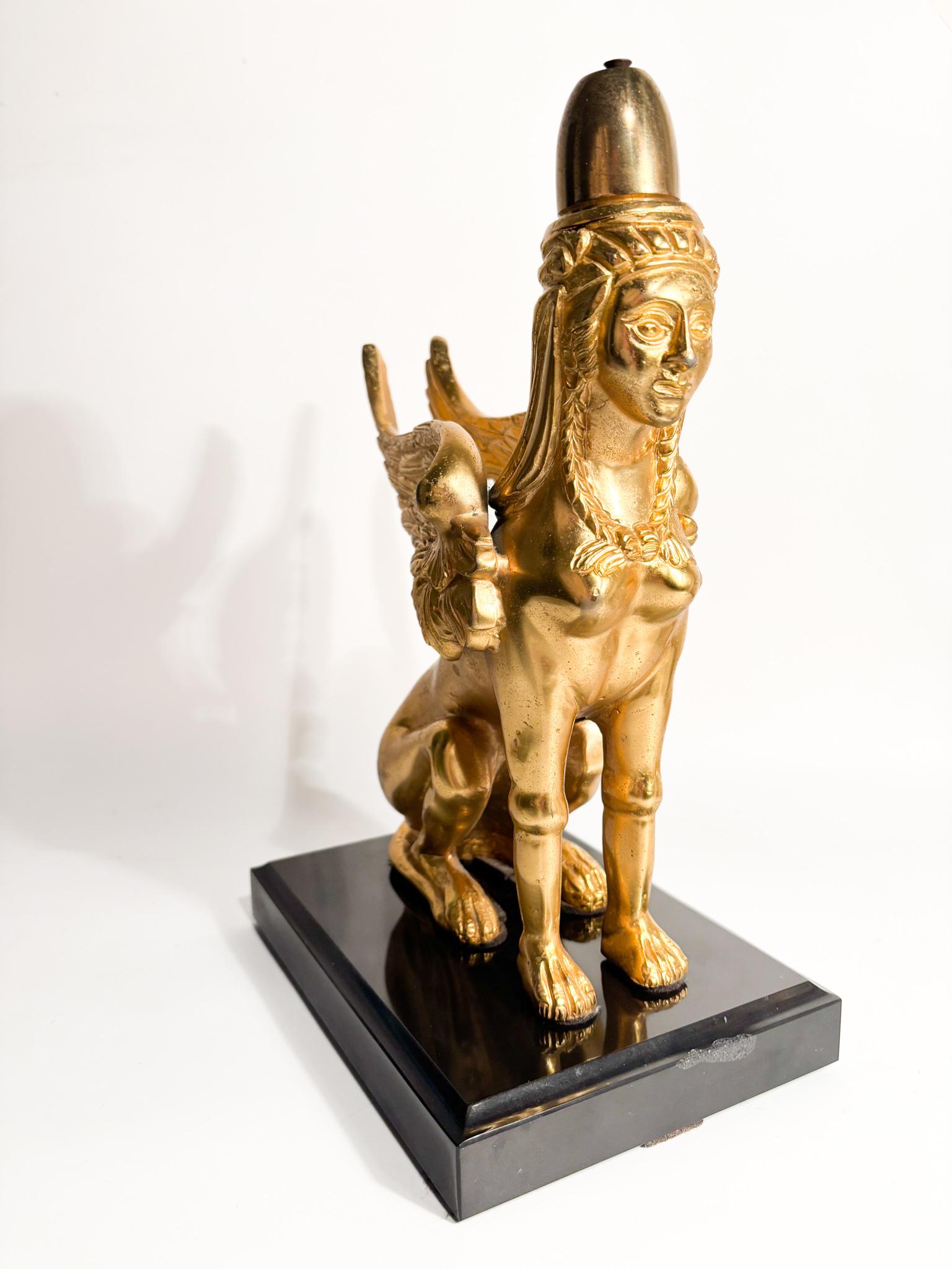 Sculpture représentant le Sphinx en bronze doré, reposant sur un socle en marbre noir, réalisée au XXe siècle

Ø 23 cm Ø cm 15 h cm 32

Le Sphinx est une créature mythologique qui fascine l'imagination humaine depuis des millénaires. 
Le Sphinx
