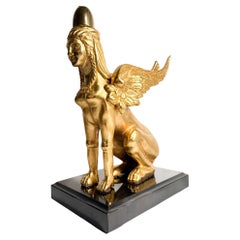 Escultura de esfinge de bronce dorado sobre base de mármol del siglo XX