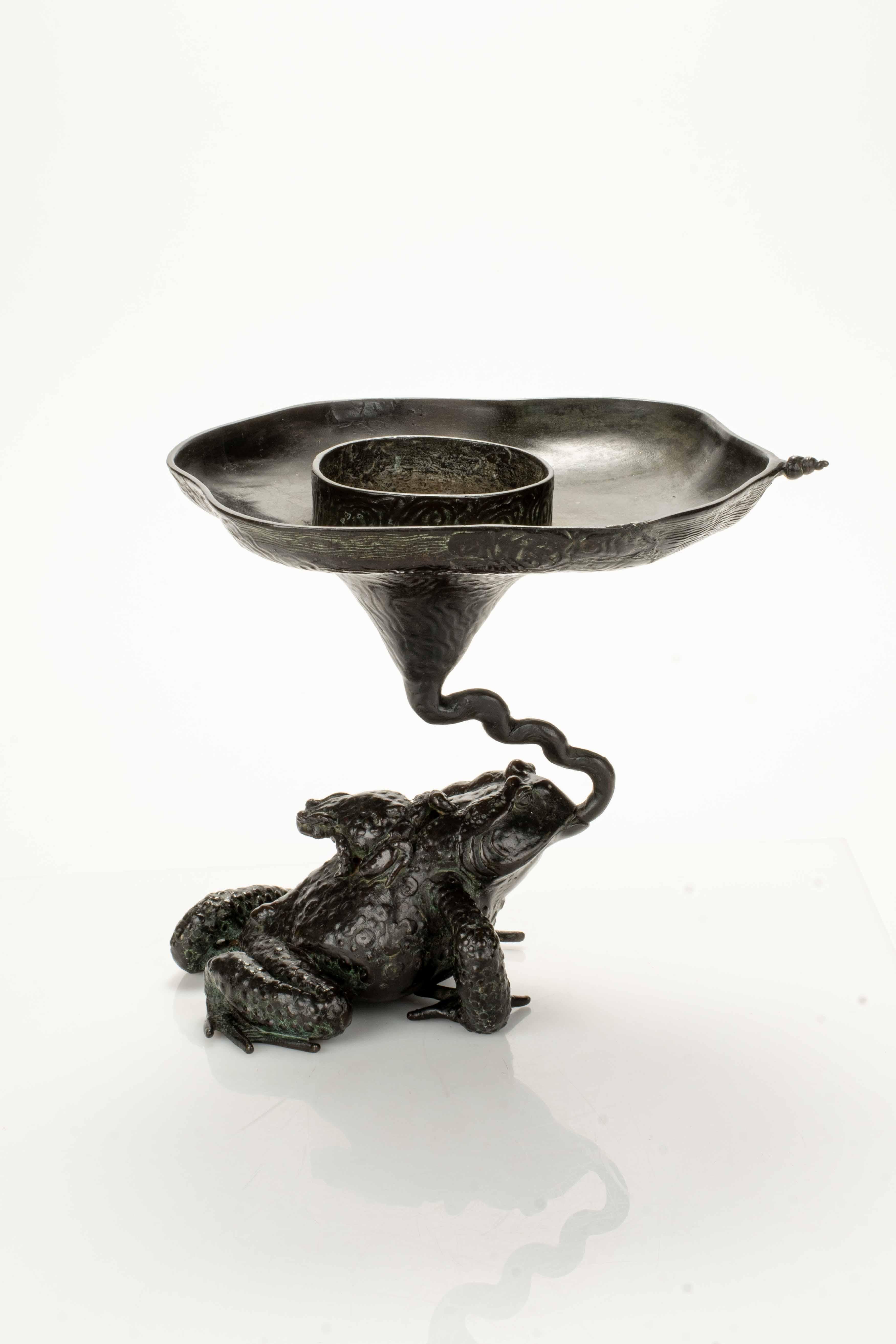 Sculpture en bronze représentant un crapaud avec son petit, tenant par la bouche un vase ikebana ouvert en forme de fleur.

Signature gravée sous le ventre du crapaud.

Période : Edo, 19ème siècle
Dimensions : 24 x 24 x 30 cm
État : Très bon état.