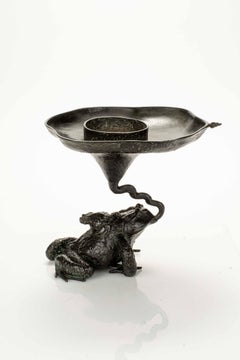 Bronze sculpture depicting two toads with an ikebana vase