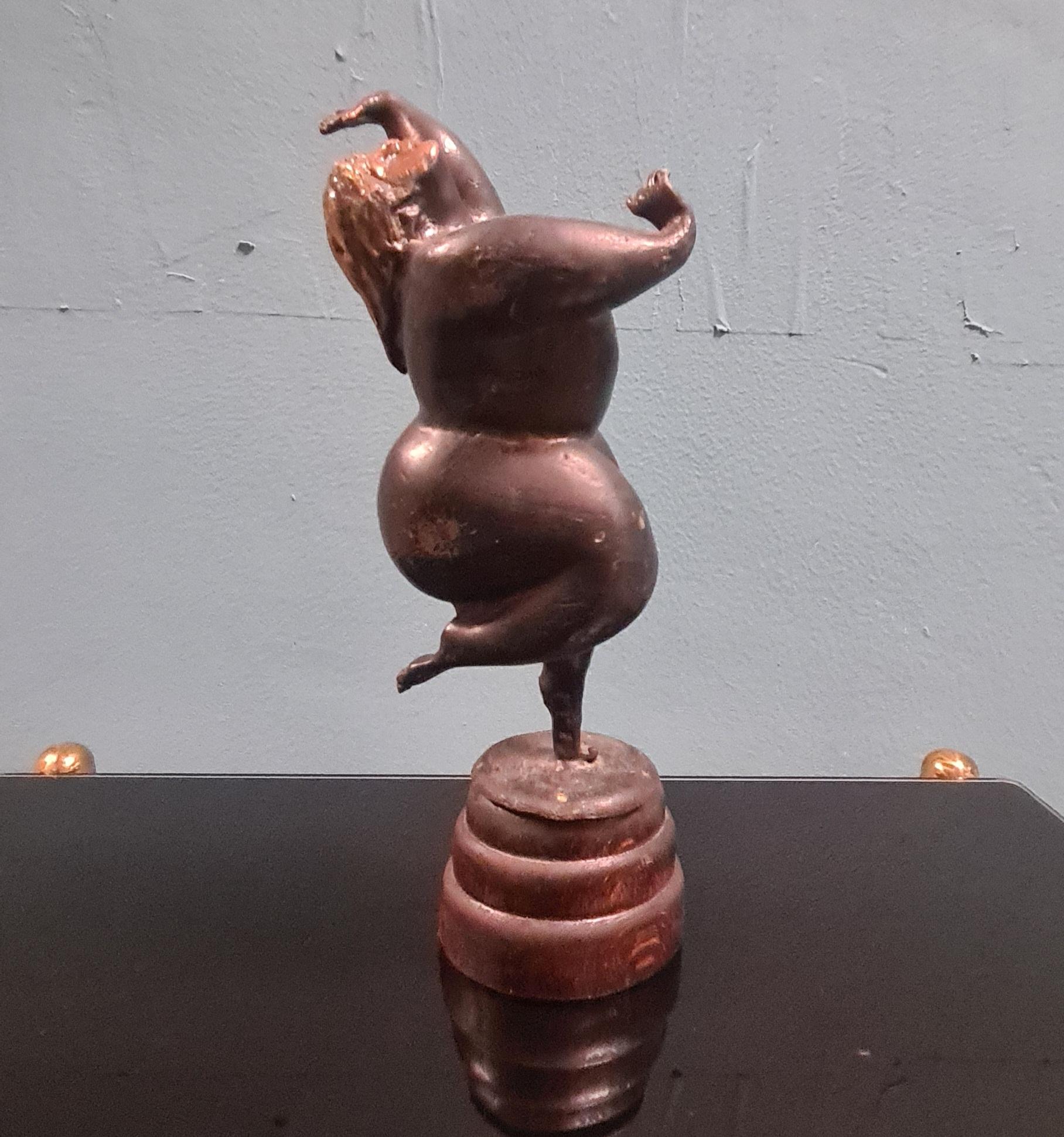 Bronze sculpture depicting female nude.

Small statue made of bronze with parts, such as the face, gilded with mercury and wooden base.

The sculpture depicts a sinuous female figure with abundant forms in a dancing pose that exudes joy.

It is
