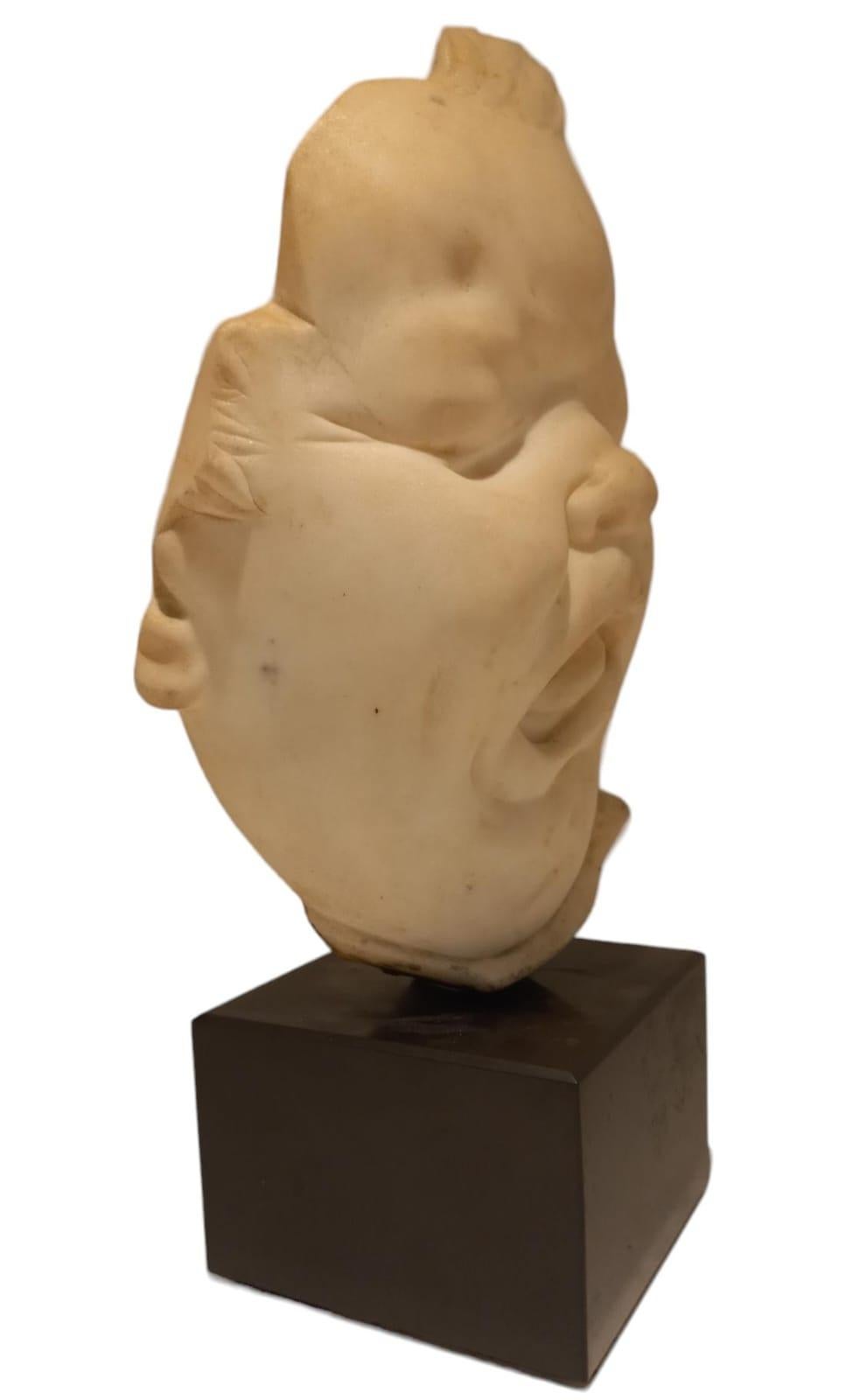Carved White marble sculpture depicting the face of a child with grimace For Sale