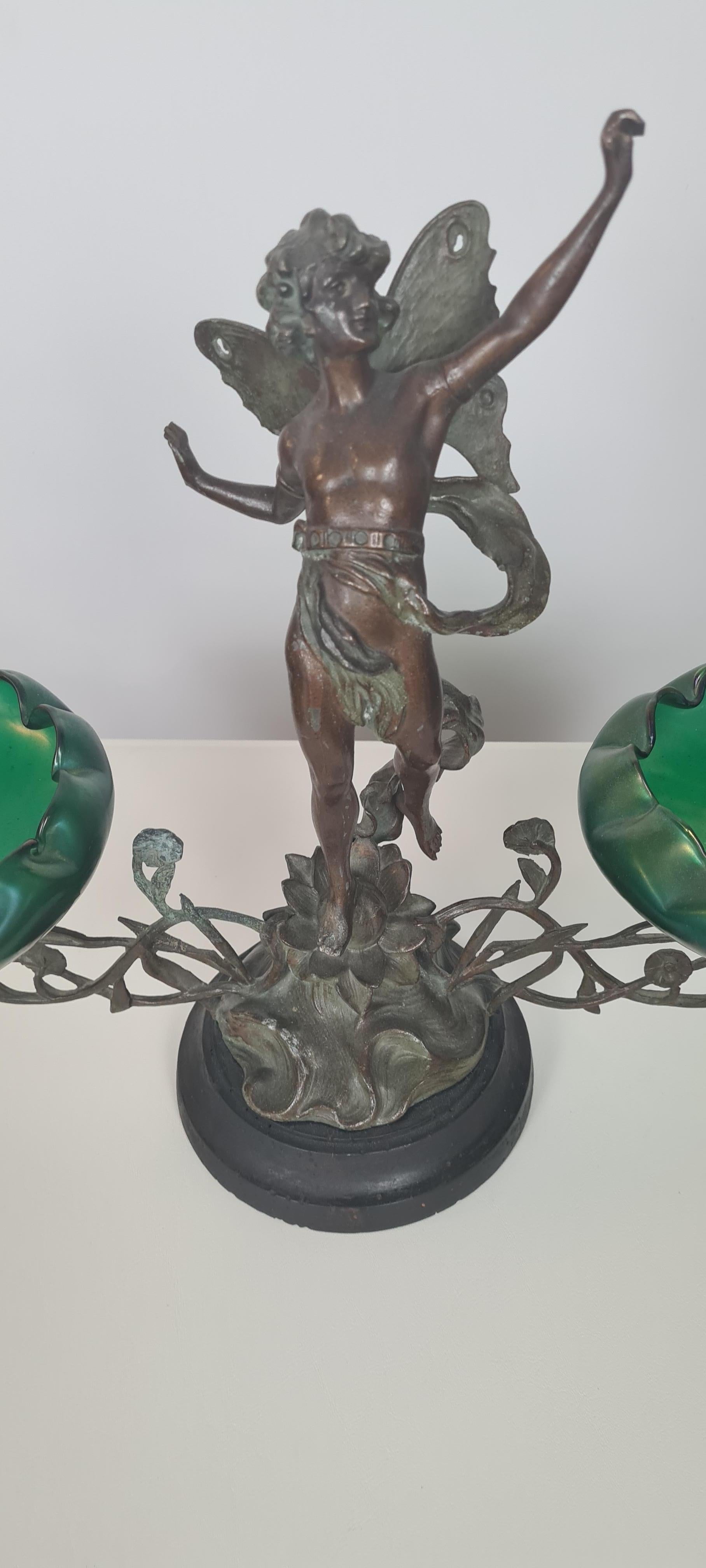 Svuotatasche liberty dei primi del 900′, composto da una scultura di fanciullo alato in bronzo e due coppe in vetro verde, lavorato a mano.

Notare la maestria e bravura nel dare vita e movimento al fanciullo.

La scultura-oggetto si trova in
