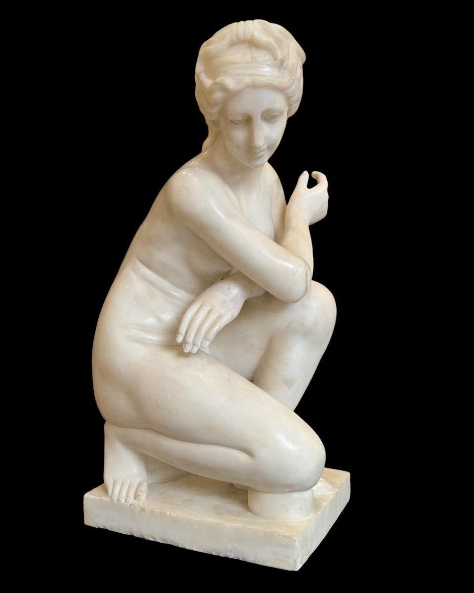Scultura raffigurante Venere accovacciata in marmo bianco di Carrara del XX secolo.

La scultura raffigura la dea dell'amore e della bellezza, Venere, in una posa intima e pudica durante il bagno.
La dea è accovacciata con la gamba destra aderente