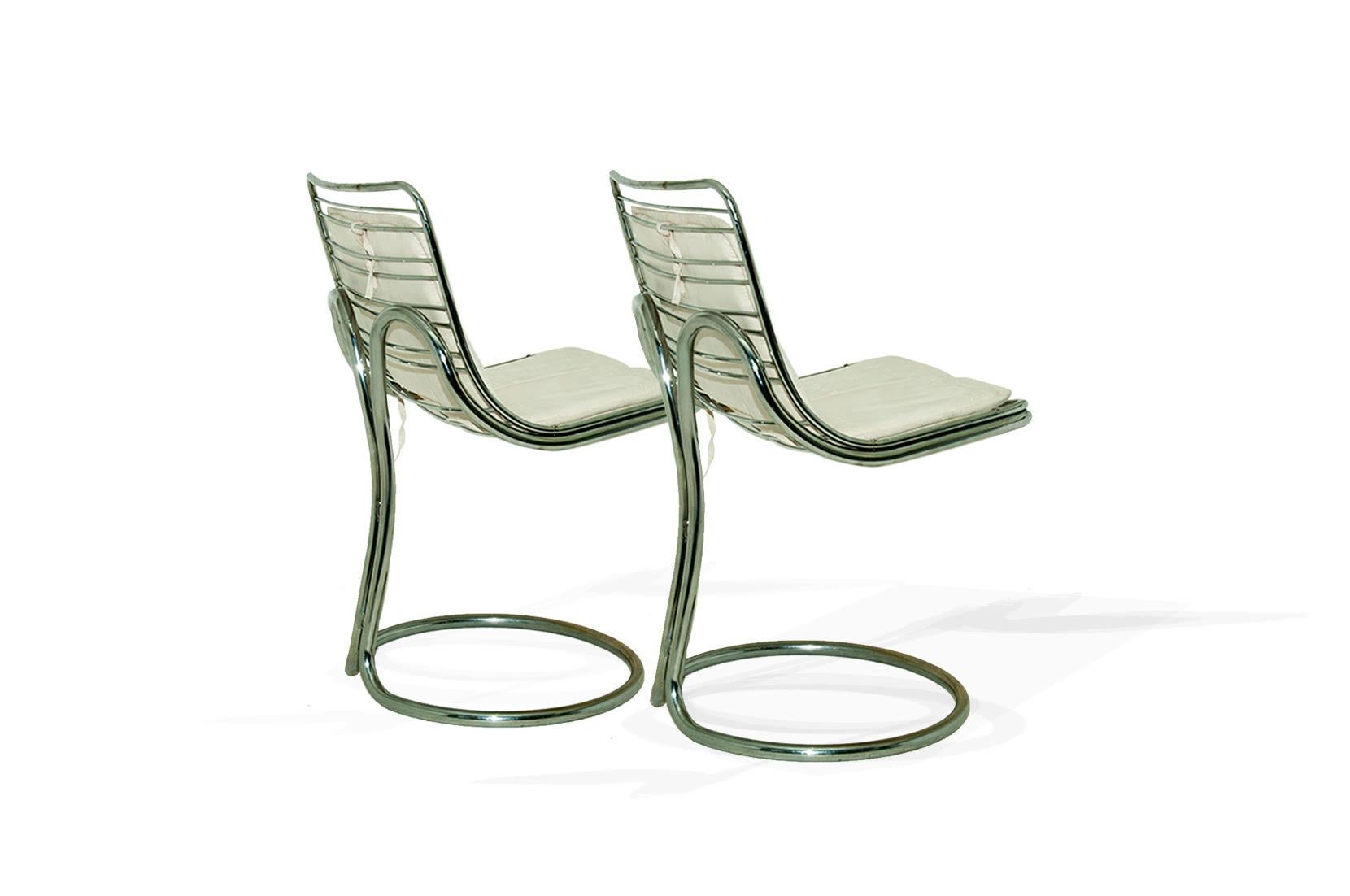 These chairs has, an extraordinary sculptural shape, made by the twist of the chromed metal tubes, in the back. The seats are covered with an amovible white Alcantara cover.
The feet are in circle, a round shape, with the tubes forming a circle.