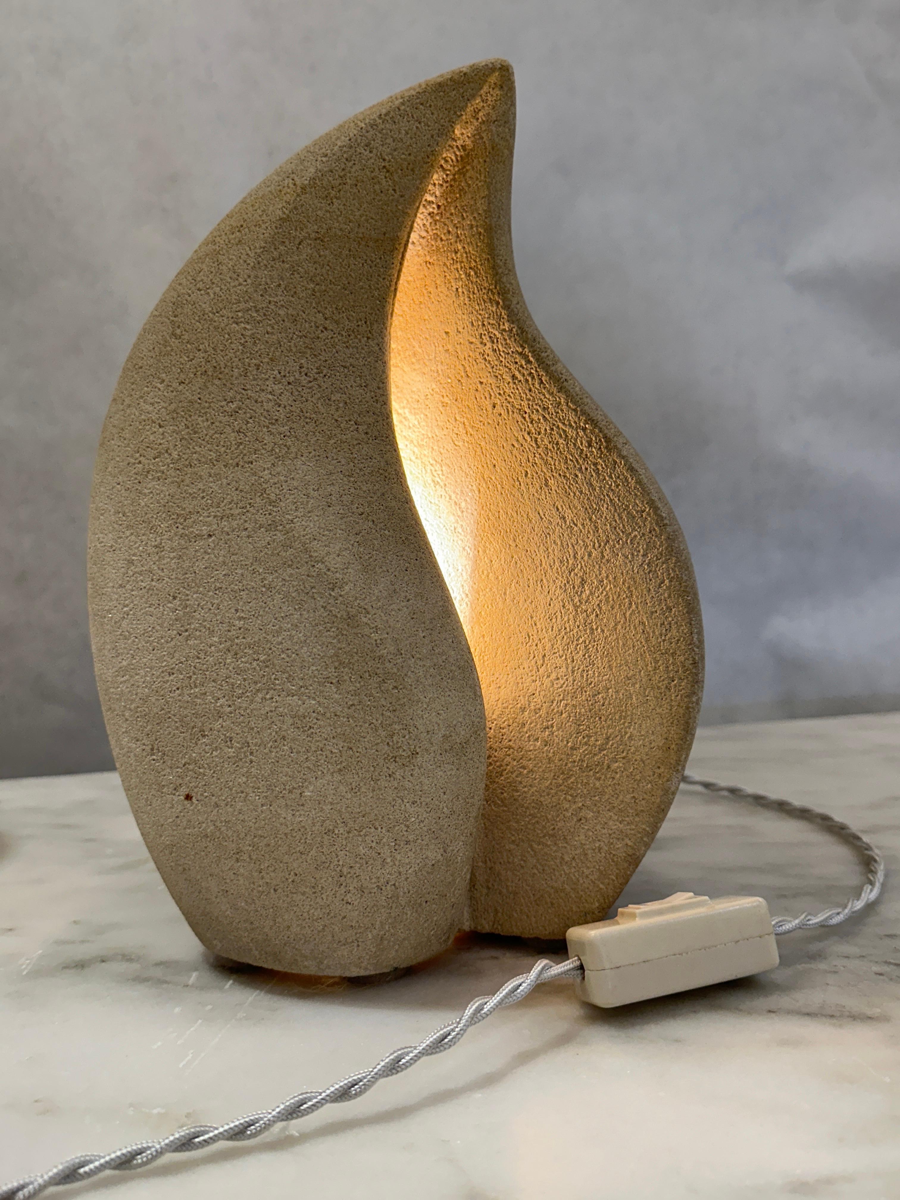 This is an extremely sculptural stone table lamp by French sculptor, Arsene Galisson.  He creates small architectural lamps and objects inhabited by a soft light, a constant presence. Signed by the artist, the lamps are made from Chauvigny stone. 