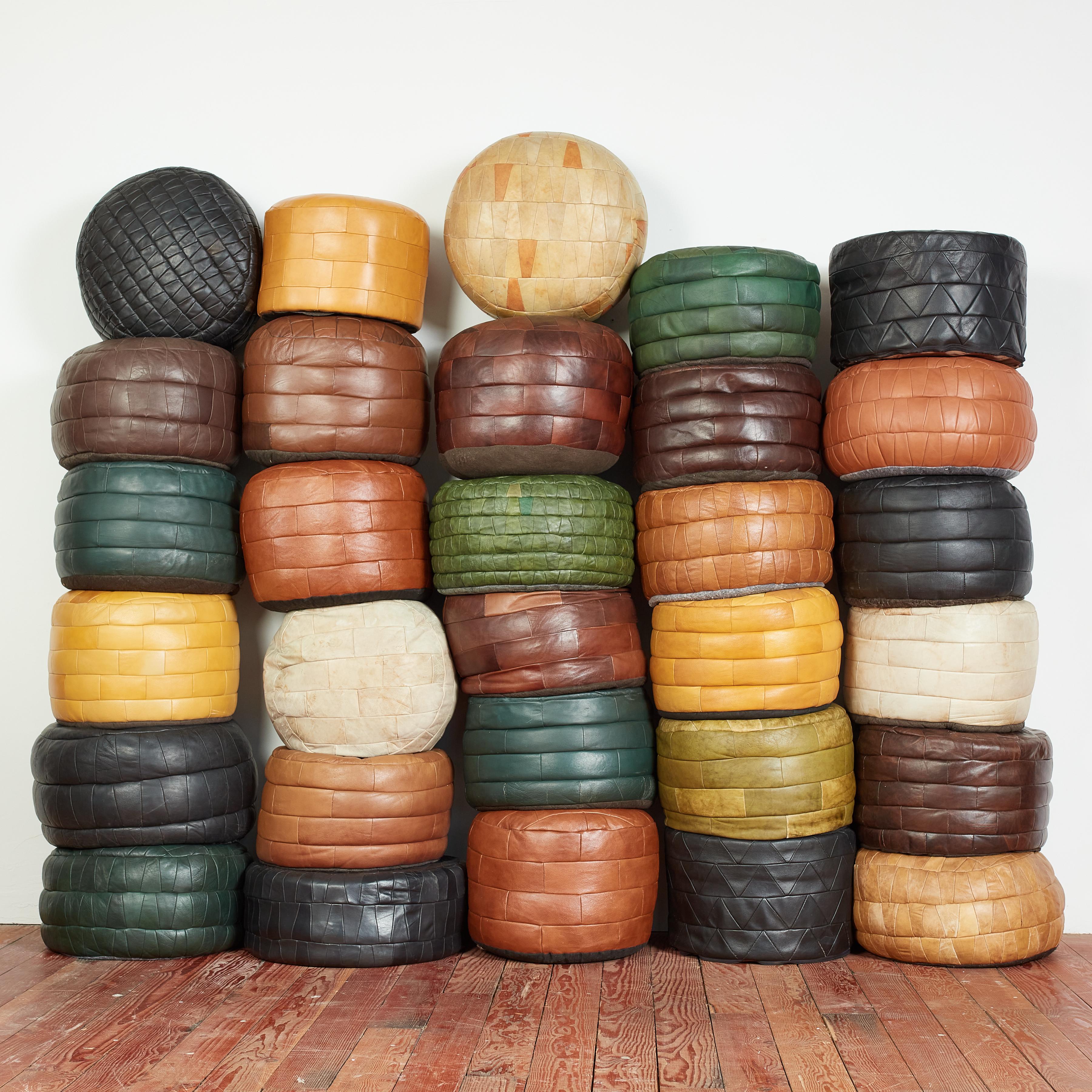 Large collection of patchwork leather pouf/ottomans by Swiss designer De Sede with patchwork leather and wonderful selection of colors. 

Original soft leather with beautiful patina and age. 

Multiple colors, sizes and shapes available - inquire