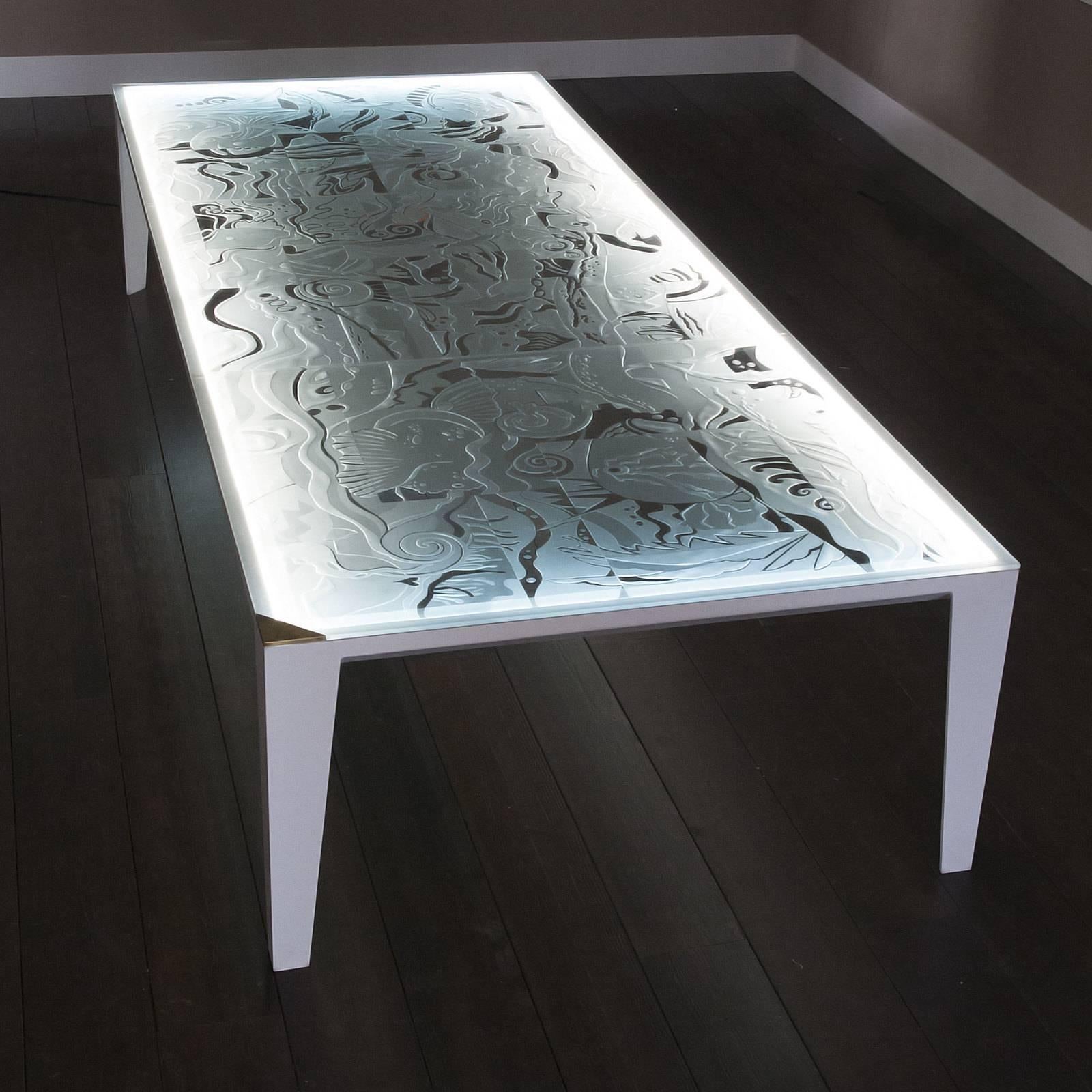 A Classic piece with an Avant Garde twist, this stunning table is a functional work of art. The distinctive glass top features a hand-engraved, bas-relief design with sinuous marine motifs enhanced by the embedded LED system. The combination of
