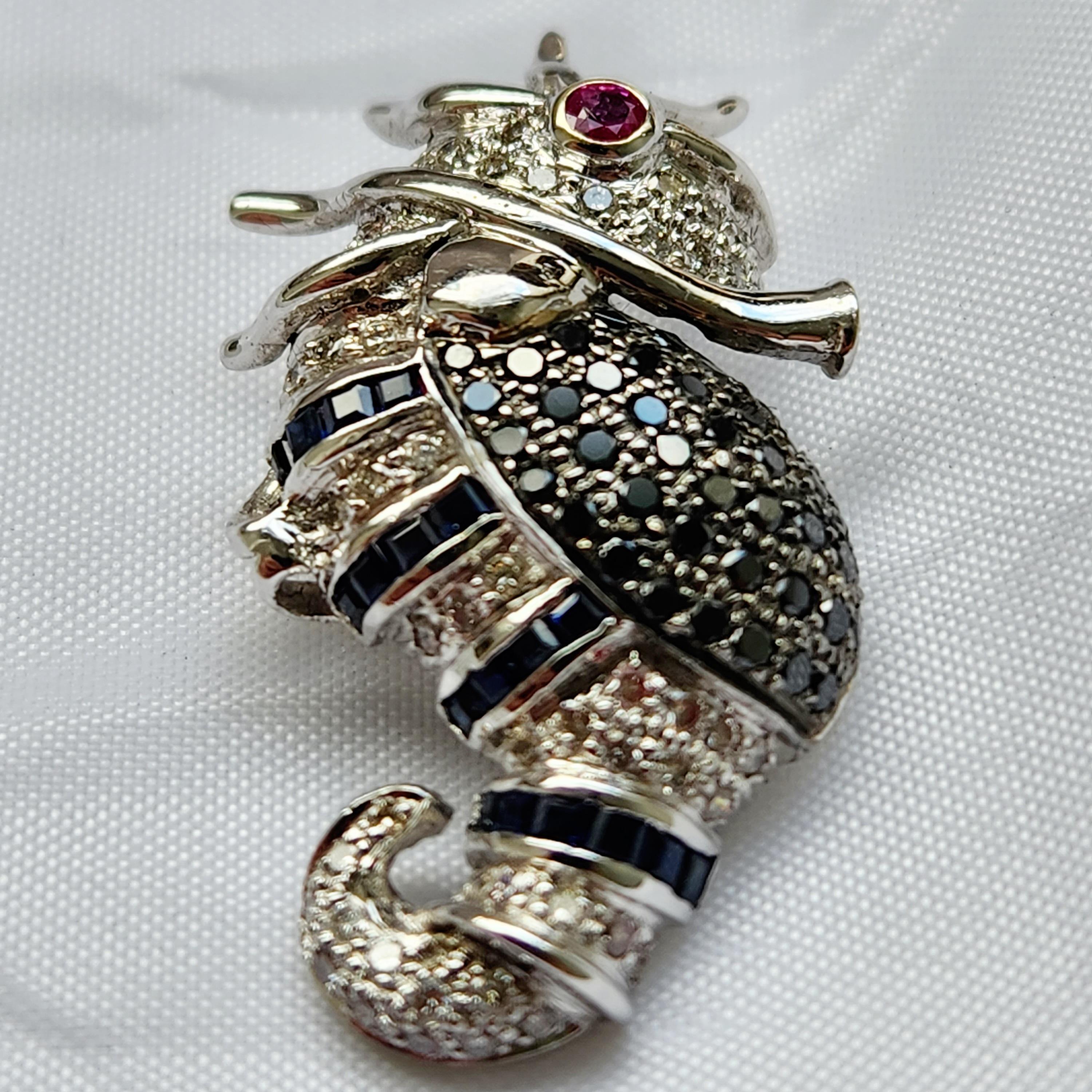 A gorgeous piece of jewelry, sea horse shaped brooch is certain to draw admiration. The centerpiece eye is an exquisitely faceted red ruby set in 18k white gold which is surrounded with full of glittering 0.92 cts of black and white melee diamonds.