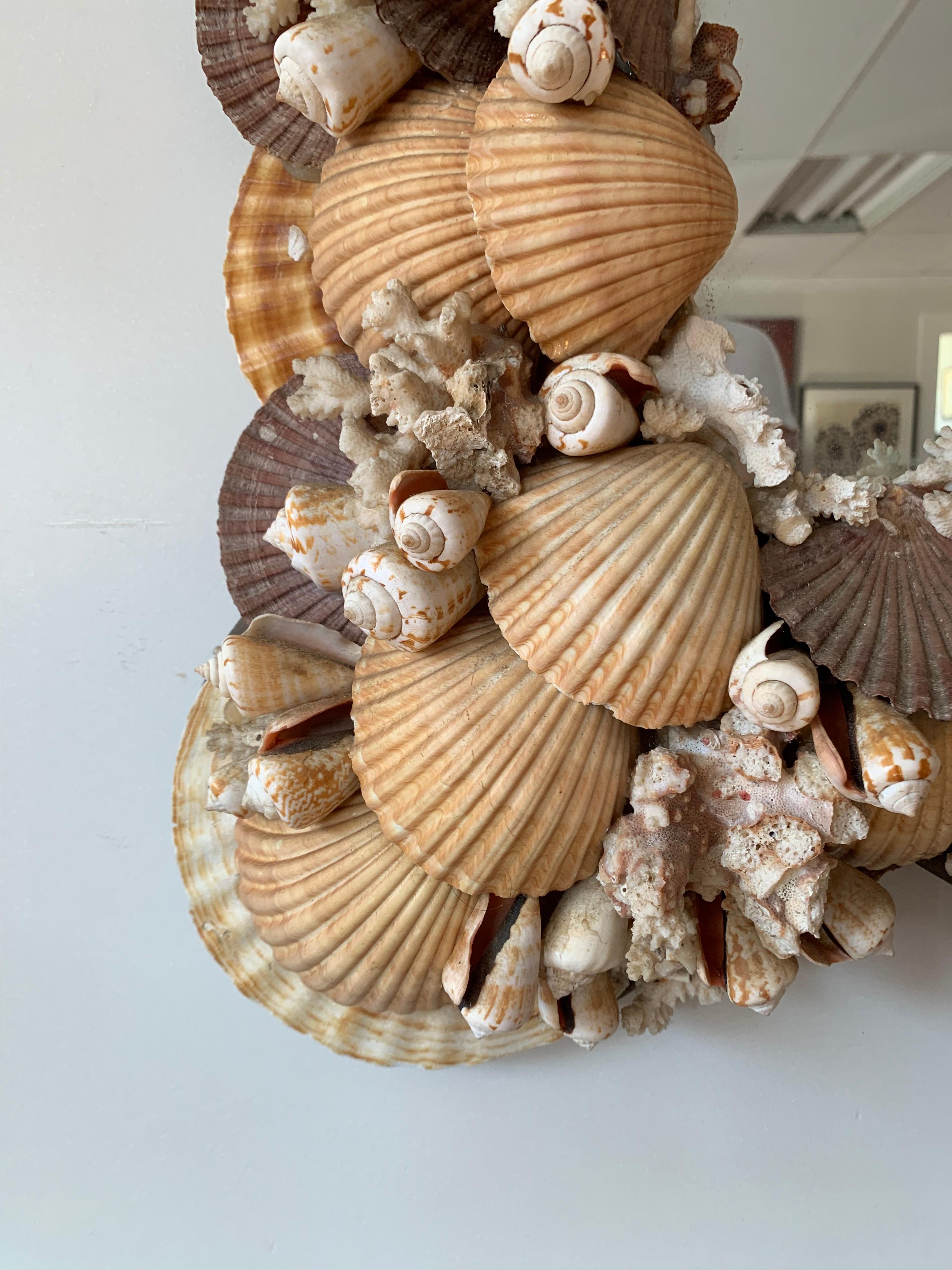 Beautiful seashell encrusted mirror is handmade of hundreds of shells and coral in all different shapes and sizes. Perfect in a powder room.