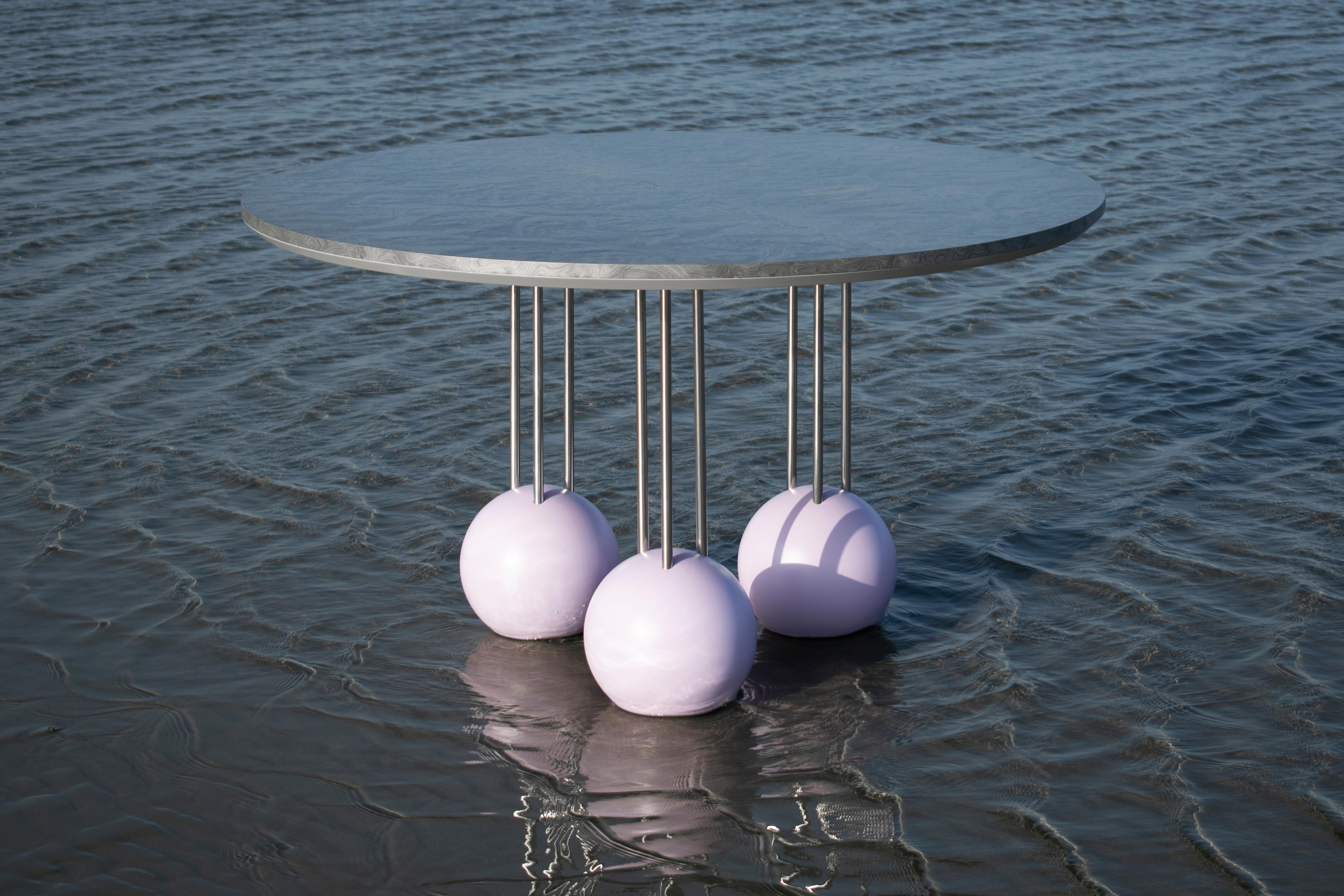 Wooden bulb veneer in silver colour, stainless steel stiles and Swedish pine solid wood spheres in lacquered pastel lilac colour.

Evolved out of its twin design, this high table’s surface reaches out to a standing height being ideal for a dining