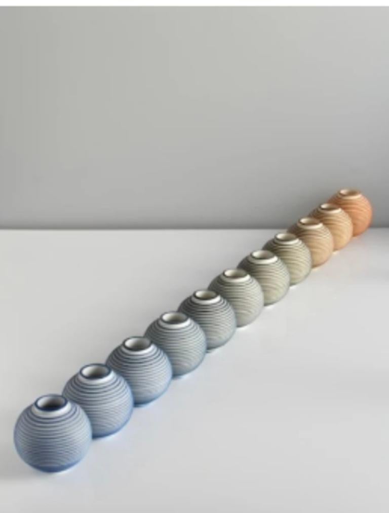 Porcelana pariana y sales metálicas solubles. Una instalación de 11 miniorbitas, que muestran una transición de color del hierro al cobalto. Tierra al agua, Tierra al mar. 