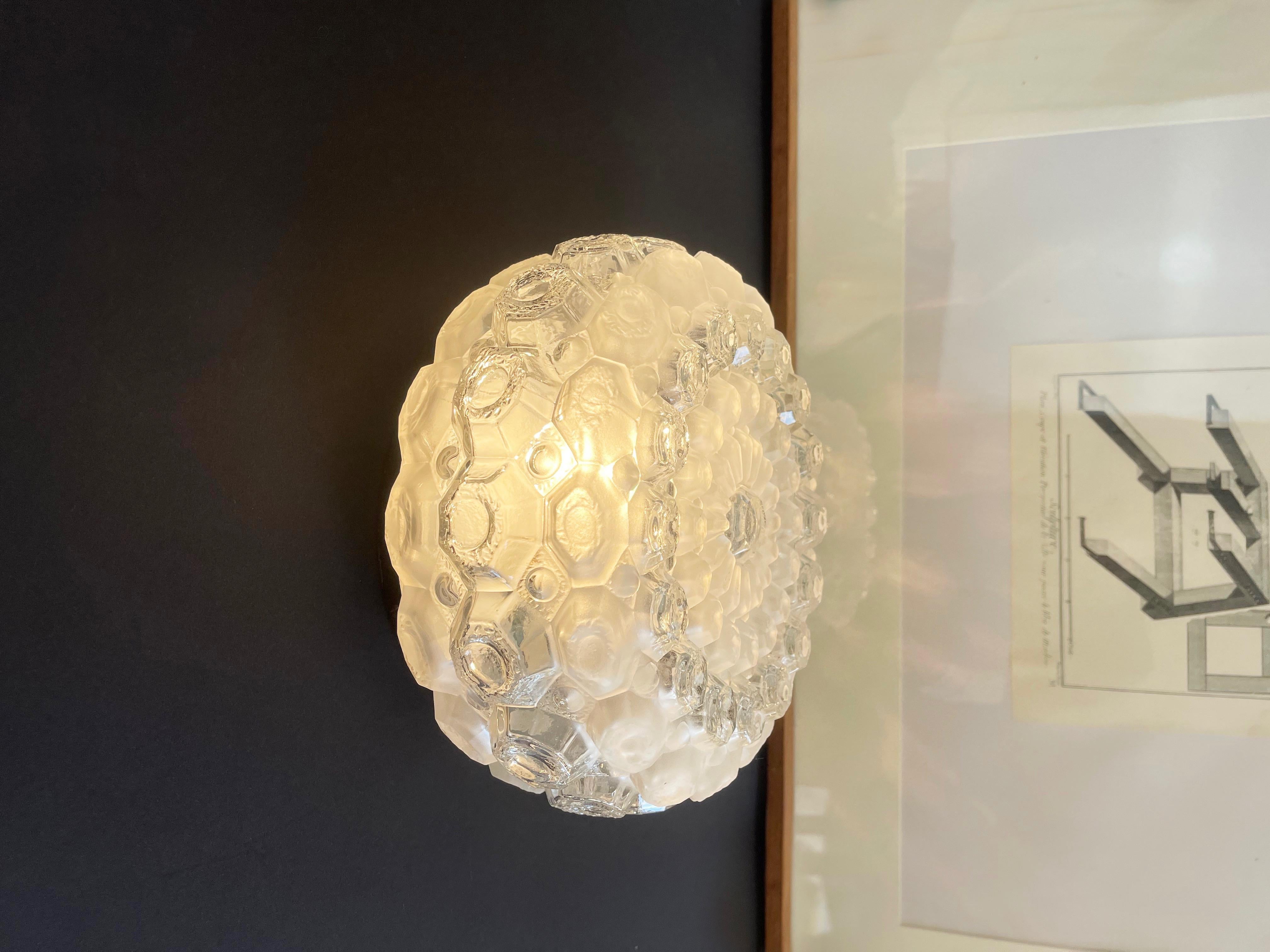 Magnifique plafonnier ou applique murale à base affleurante, probablement de Honsel, l'un des célèbres fabricants allemands de luminaires design haut de gamme du milieu du siècle dernier.
Présenté sous la forme d'un oursin rond et géométrique à