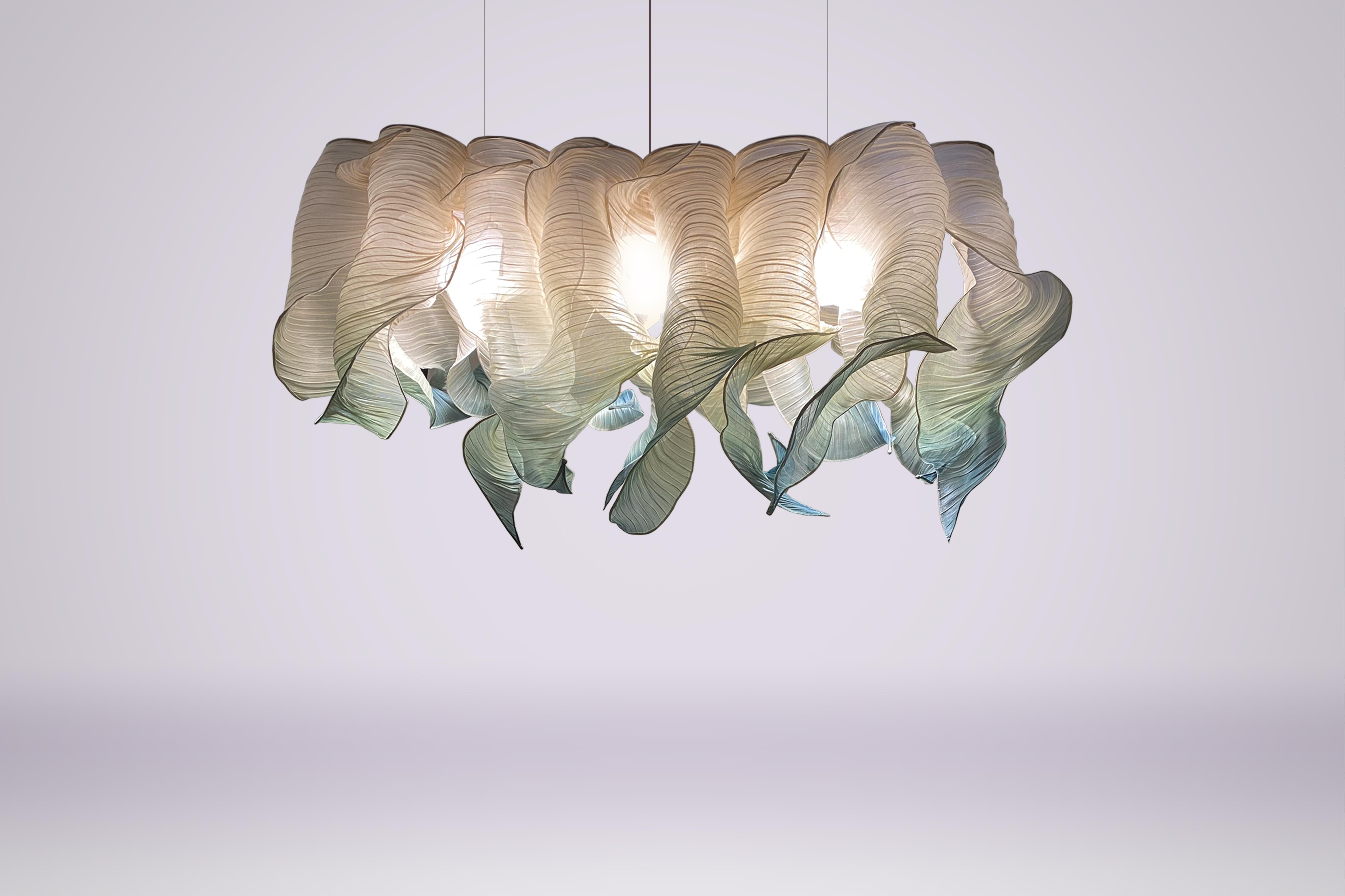 Seafoam Nebula Grande hand-painted pendant lamp by Mirei Monticelli
Dimensions: D 150 x W 50 x H 60 cm
Materials: Banaca fabric
Available in other colors.

Spiral clouds of Nebula are individually hand-painted in seafoam green to evoke memories