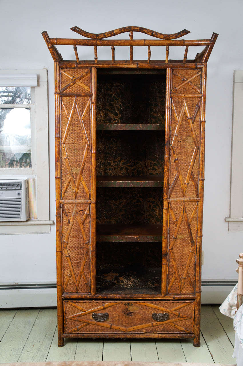 Handsome Victorian bamboo and seagrass covered armoire with (3) open shelving and lined in lincrusta paper. One-drawer with brass pulls. Can be
lighted from the interior. There is a transformer in the drawer connected
with the wiring.